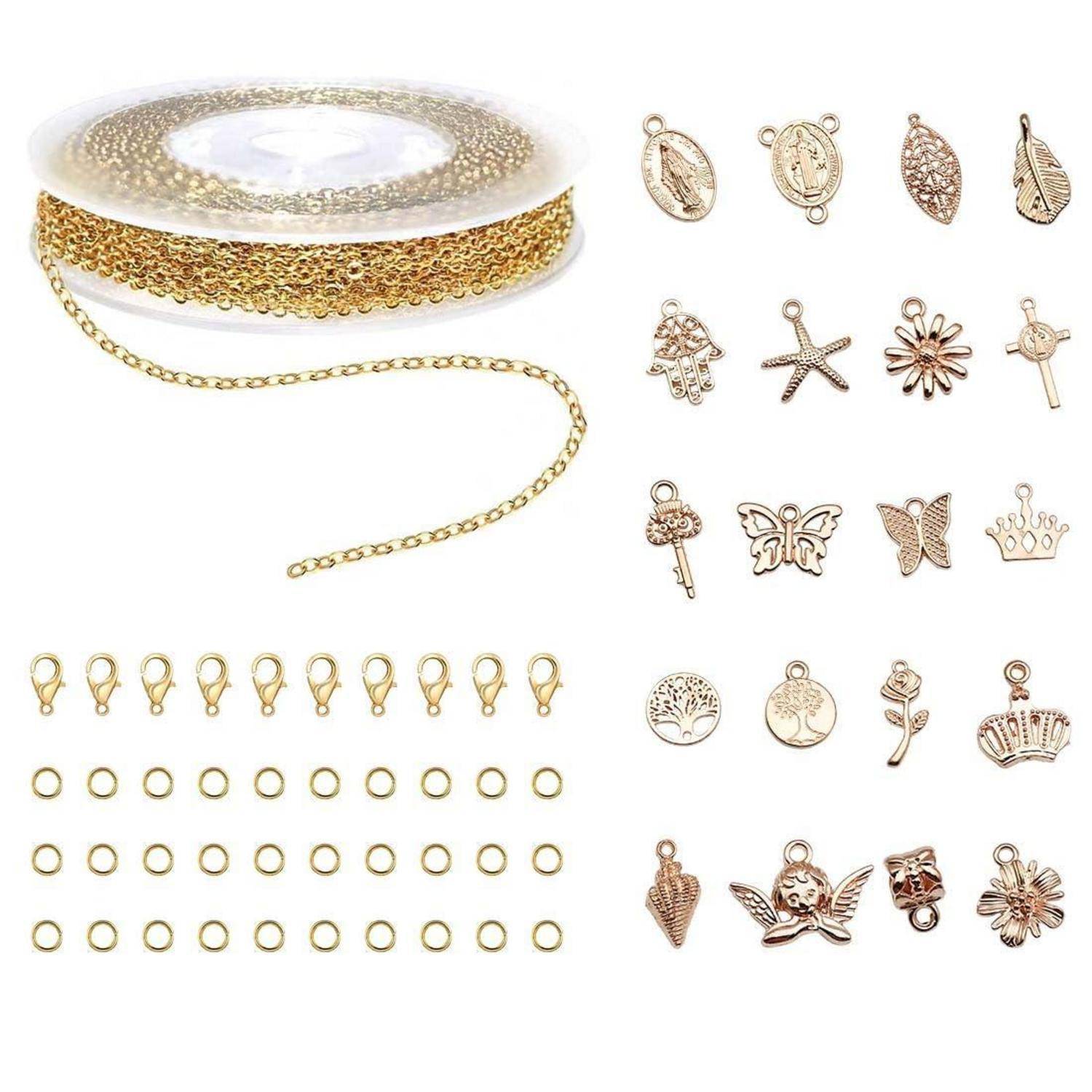 Rolle mit Goldkette mit Hummerkrallenver­schlüssen, Sprungringe und verschiedene goldfarbene Charmananhänger auf weißem Hintergrund angeordnet.