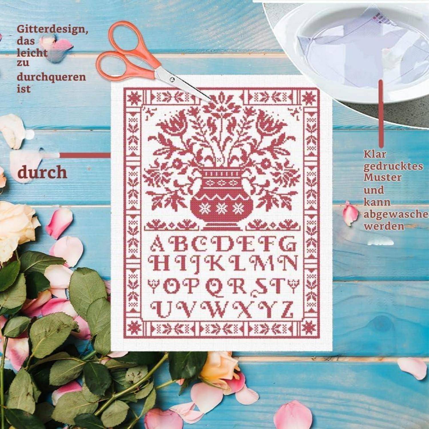Kreuzstich-Muster mit einer Blumenvase und Alphabet, gezeigt mit Schere und einem Hinweis, dass das Design leicht nachzuzeichnen ist und waschbar ist, wenn es klar gedruckt wird.