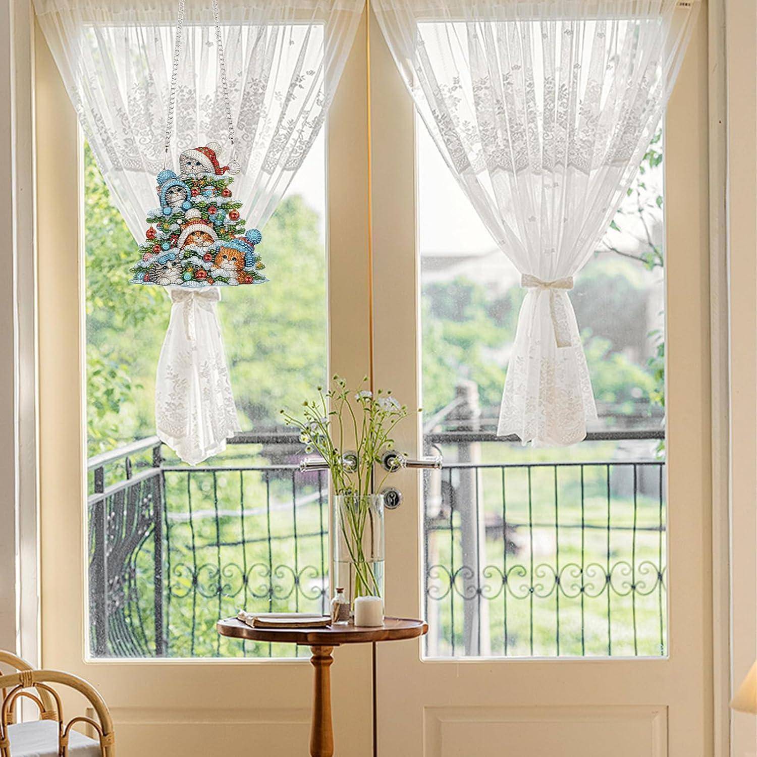 Sonnendurchfluteter Raum mit Glastüren und durchsichtigen Vorhängen; eine farbenfrohe Winterdeko-Hängdekoration am linken Vorhang und ein kleiner runder Tisch mit Blumen darunter.