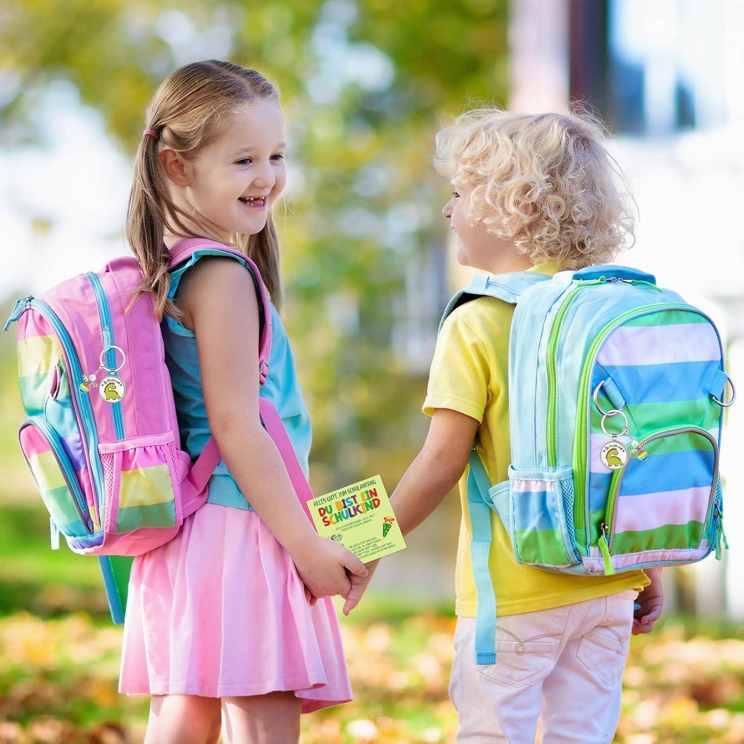 Ein lächelndes Mädchen und ein Junge mit Rucksäcken halten sich an den Händen und halten eine "Zurück zur Schule""-Karte im Freien.