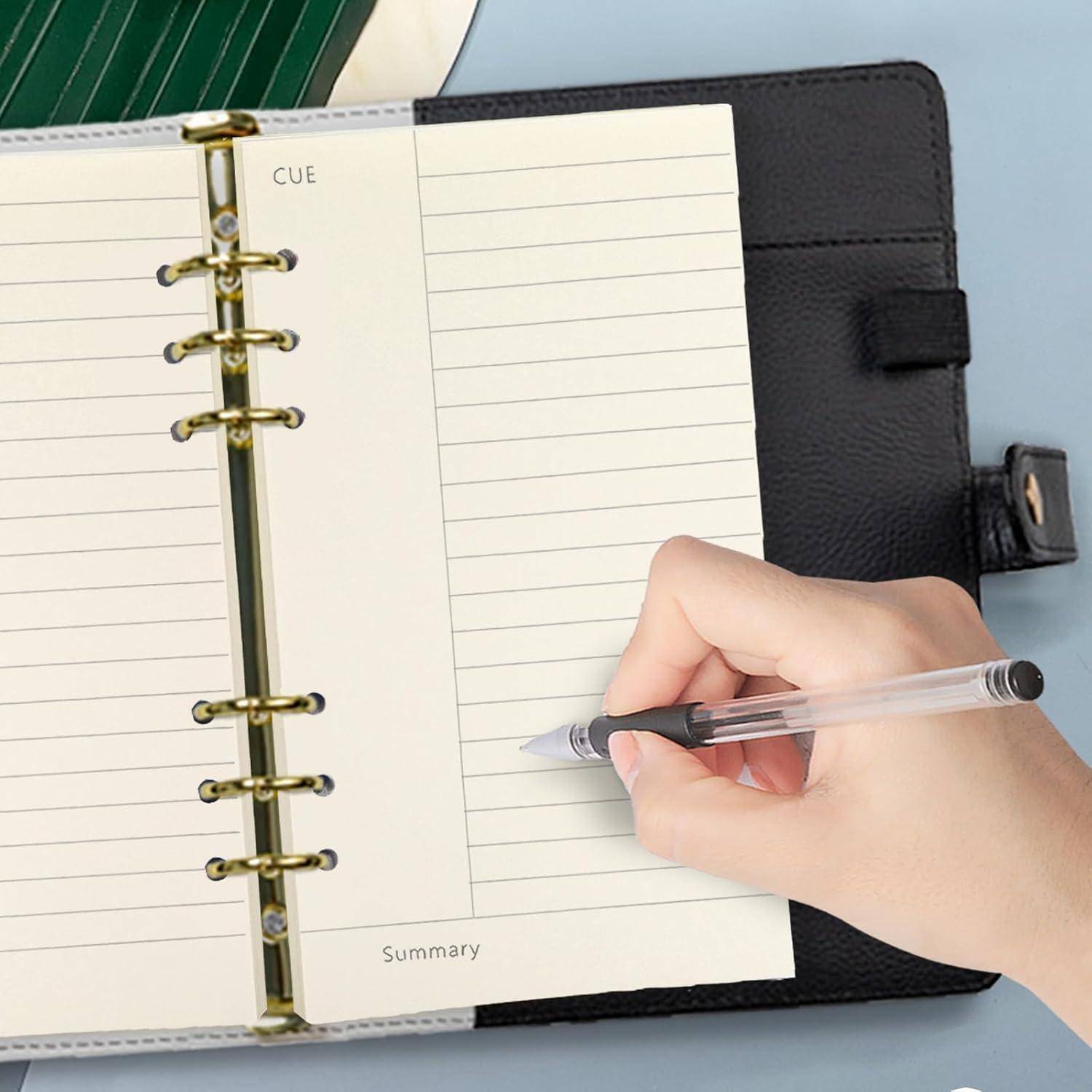 Hand schreibt in einem leeren spiralgebundenen Planer-Notizbuch mit den Aufschriften „CUE