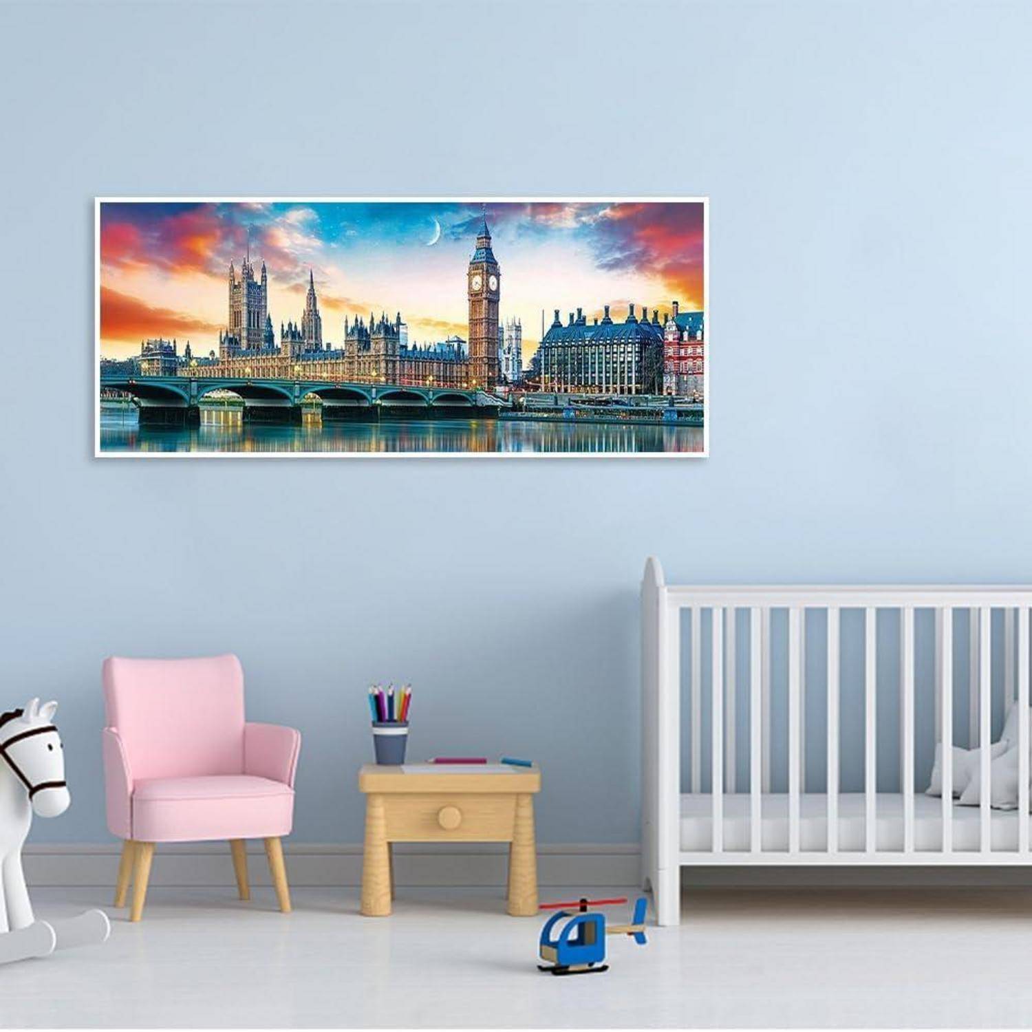 Ein Kinderzimmer mit einem rosafarbenen Stuhl, einem Spielzeugtisch, einem Kinderbett und einem Spielzeugteppich; darüber hängt ein gerahmter Druck der Londoner Skyline mit dem Big Ben und dem Palace of Westminster bei Sonnenuntergang.