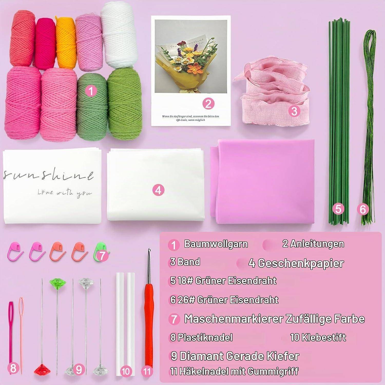 Geschenkverpackungs-Bastelset auf rosa Hintergrund ausgelegt, zeigt farbige Baumwollgarne, Anleitung, rosa Band, Seidenpapier, grüne Drähte, Häkelwerkzeuge, Sicherheitsnadeln, Nadel und Klebestift.