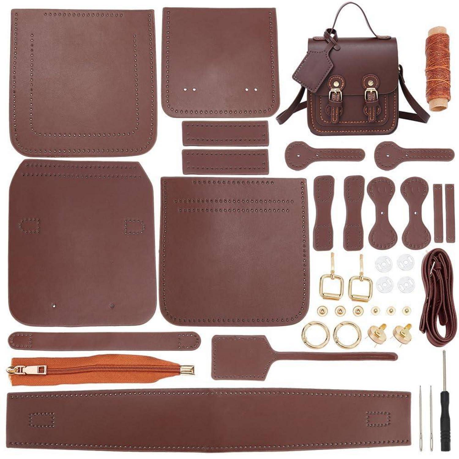 Lederhandtaschen-Bastelset mit mehreren braunen vorgefertigten Teilen, Riemen, Beschlägen, Garn, Reißverschluss und Werkzeugen sowie einem kleinen zusammengebauten Handtaschenbeispiel.