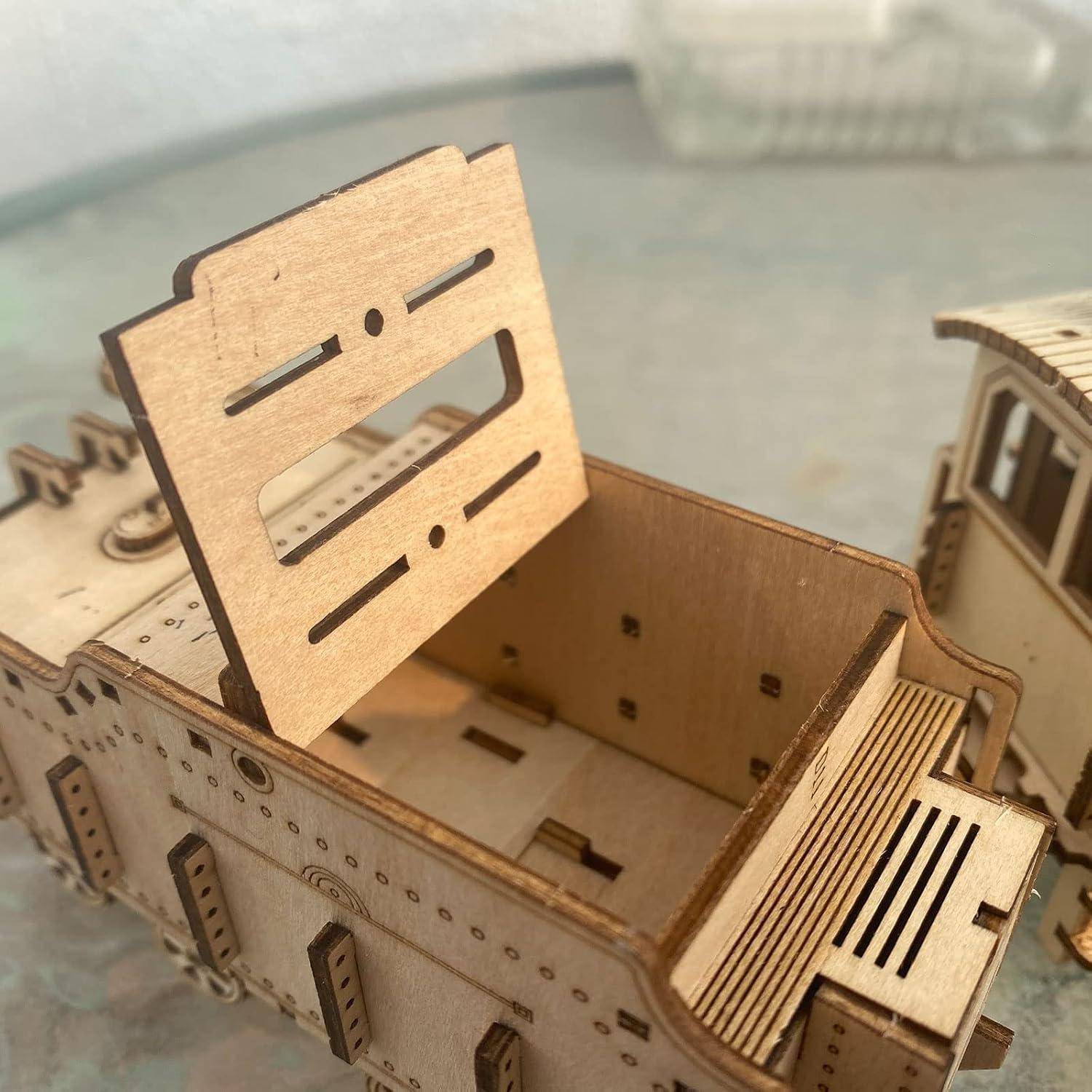 Lasergeschnittenes Holzmodell eines offenen Lastwagens oder Wagens, mit einem großen Seitenpaneel, das aufrecht steht, und einem weiteren Modellstück in der Nähe.