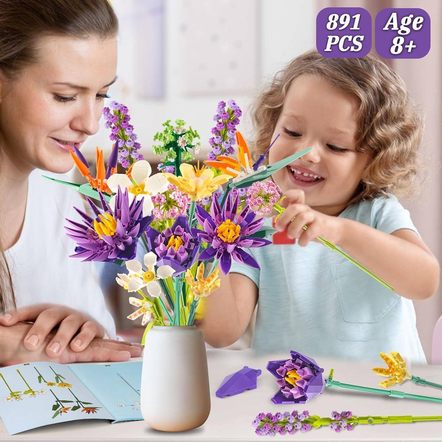 Mutter und Kind bauen einen bunten LEGO-ähnlichen Blumenstrauß in einer Vase zusammen; das Etikett zeigt „891 TEILE" und „Ab 8 Jahren"".