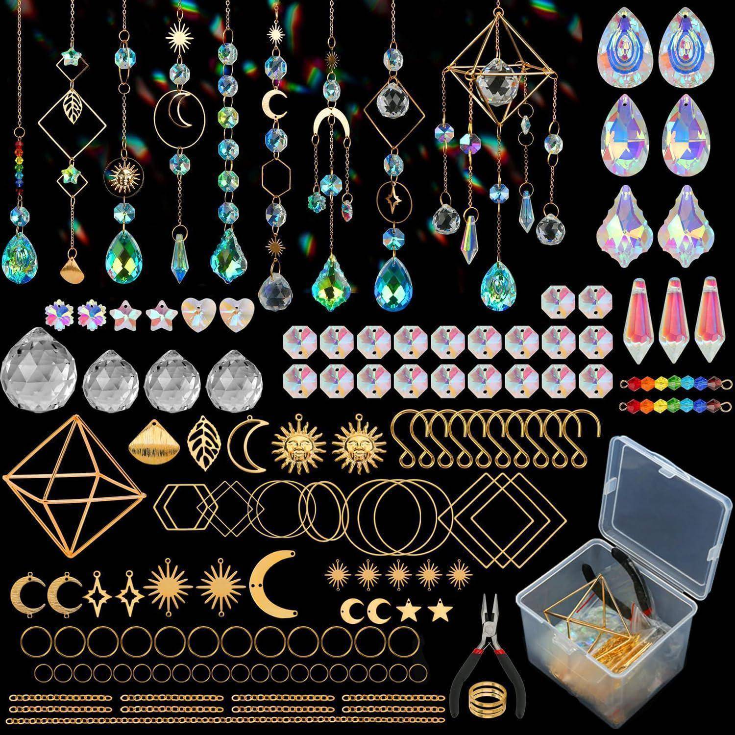 Sortierte Schmuckherstellungskomponenten und Werkzeuge: Kristallanhänger, Tropfenperlen, geometrische Charms, goldene Drahtformen, Sprungringe und Zangen in einer Aufbewahrungsbox auf schwarzem Hintergrund.
