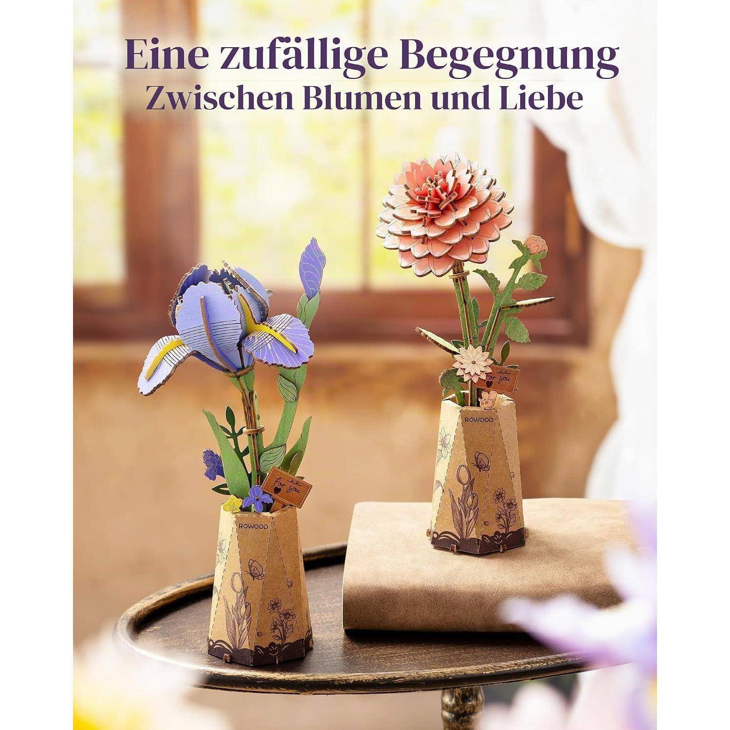 Werbeplakat mit zwei Papierblumen in Vasen auf einem Tisch; die Überschrift lautet „Eine zufällige Begegnung