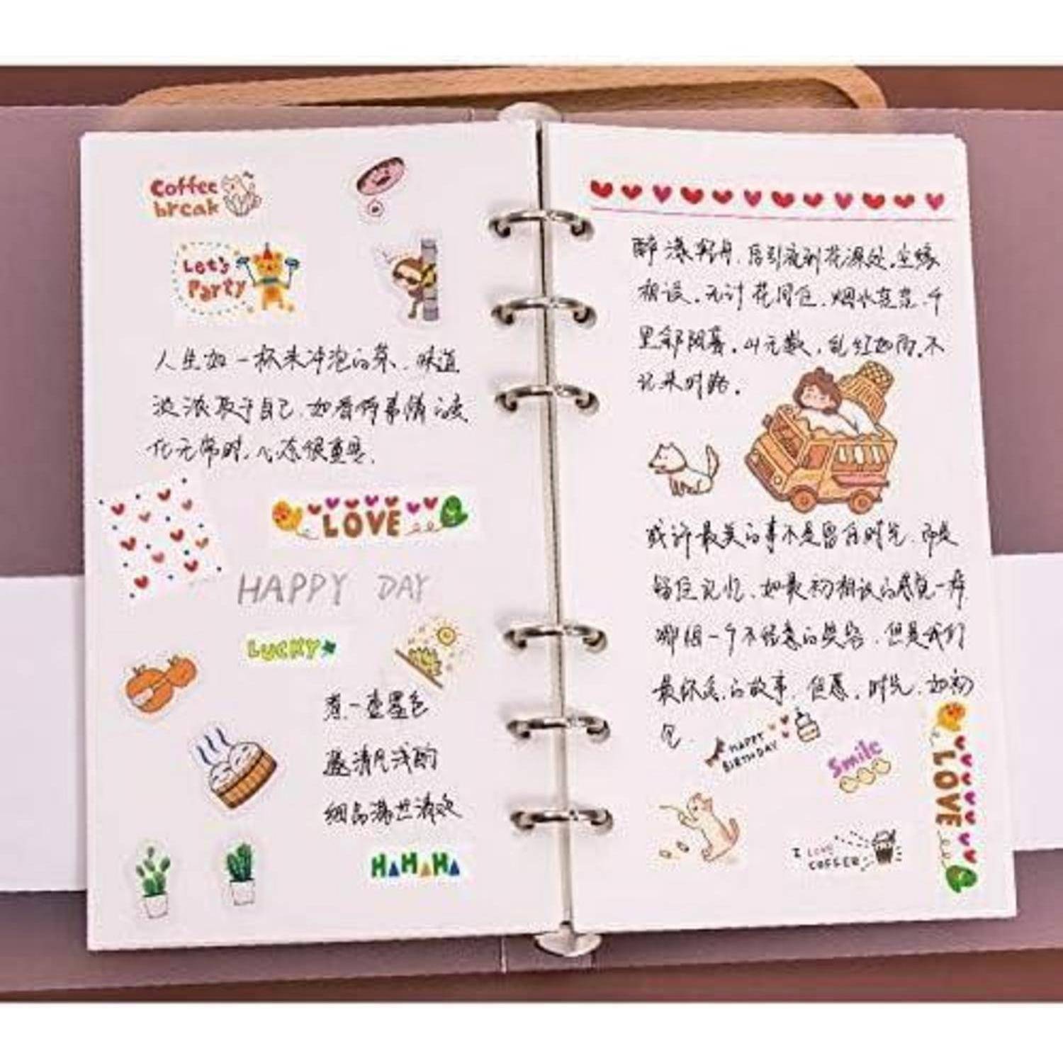 Aufgeschlagenes ringgebundenes Scrapbook mit handgeschriebenen chinesischen Notizen, bunten Aufklebern und Kritzeleien, einschließlich 