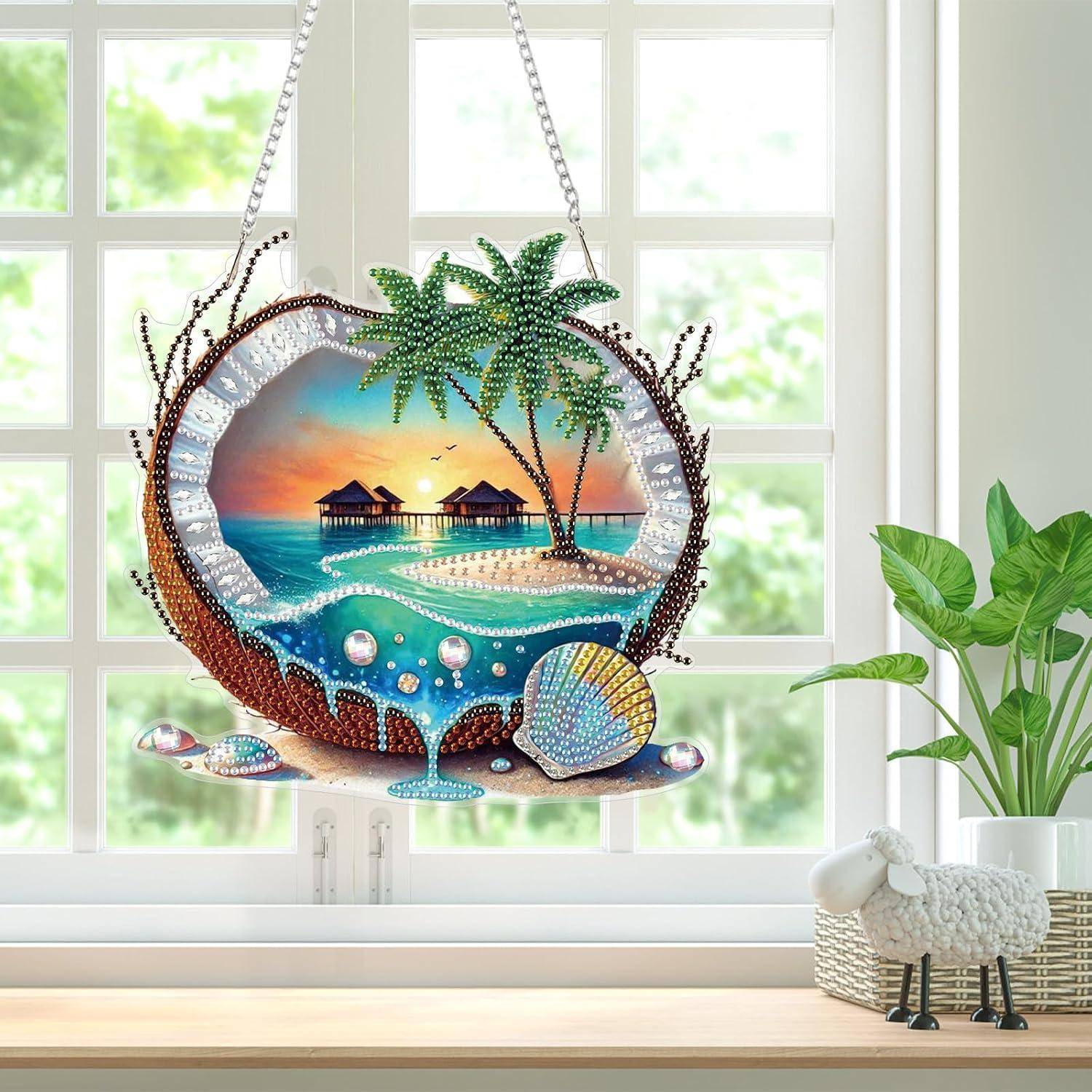 Perlenbesetztes hängendes Strandszenen-Ornament mit Palmen, Überwasser-Hütten und Sonnenuntergangsmeer vor einem Fenster.