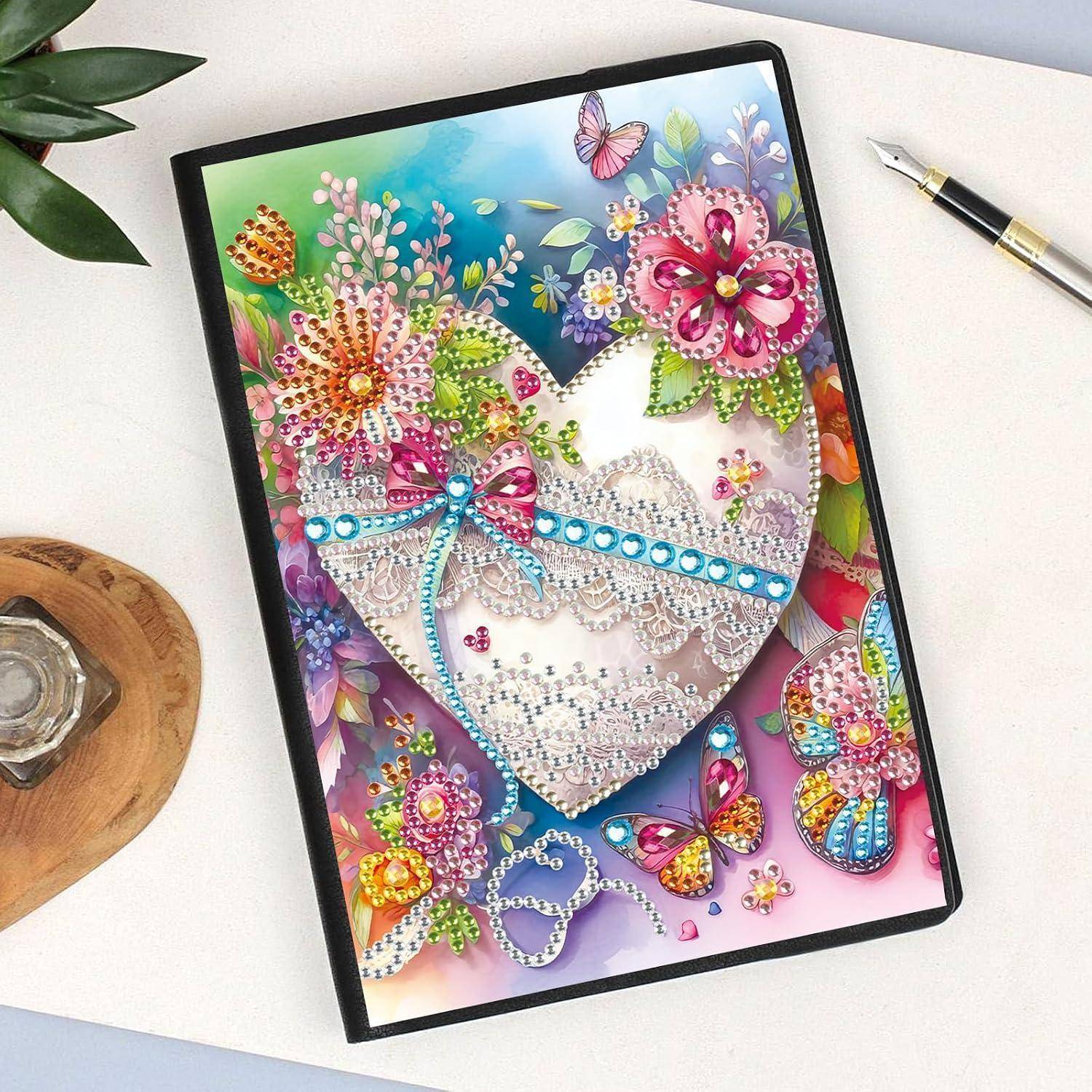Dekorative Schmuckherz-Kunstwerk mit bunten Blumen und Schmetterlingen in einem schwarzen Rahmen auf einem Schreibtisch