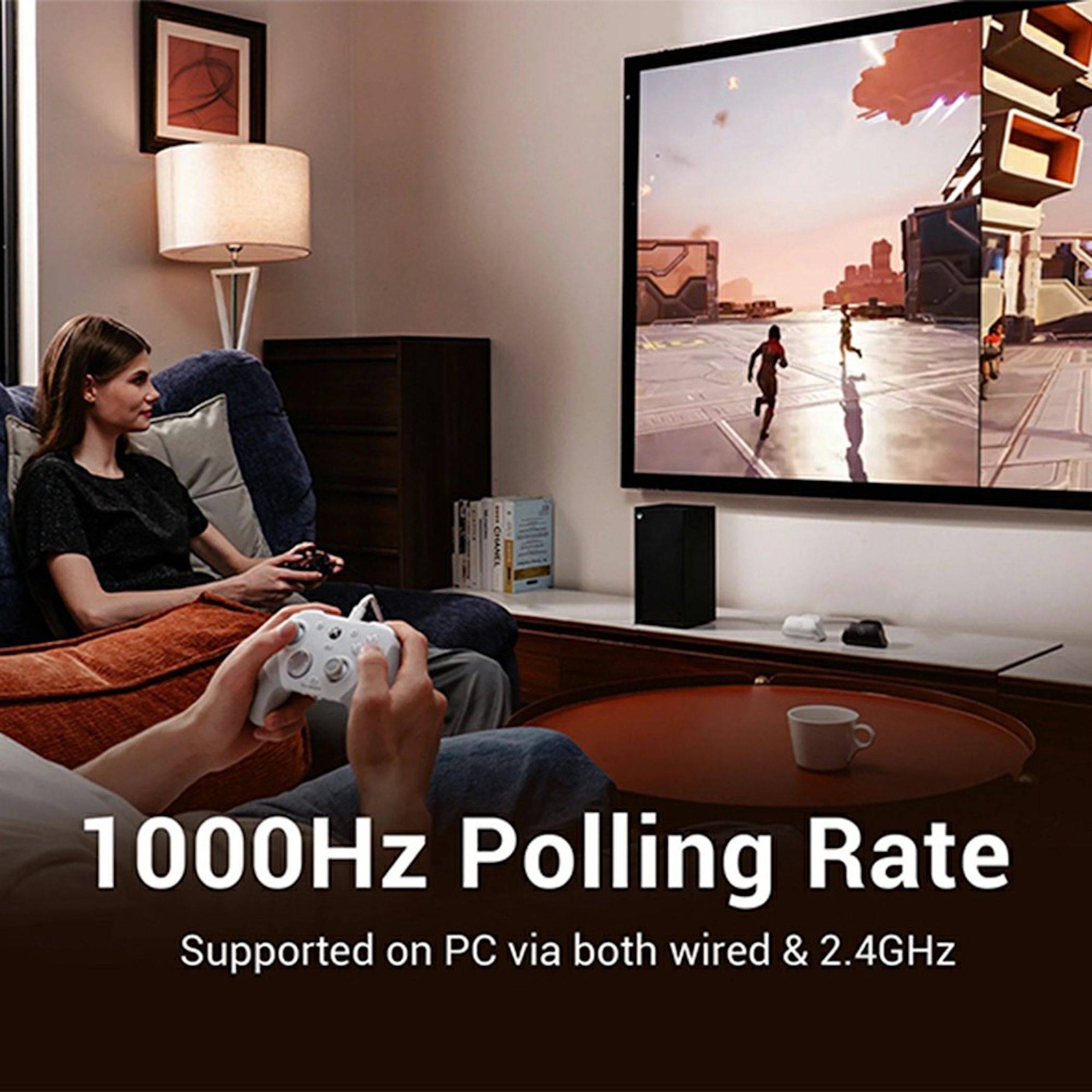 Zwei Personen spielen ein Videospiel auf einem Fernseher im Wohnzimmer; der Text lautet „1000Hz Polling Rate" und „Supported on PC via both wired & 2.4GHz"".
