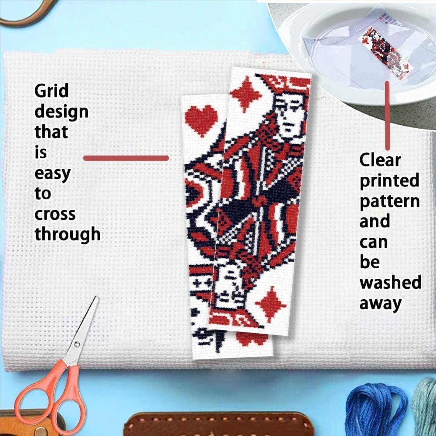 Kreuzstich-Set mit leicht zu verfolgender Rasterdesign und waschbarem bedrucktem Muster, gezeigt mit Schere, Garn und einem Beispielmotiv im Spielkartenstil.