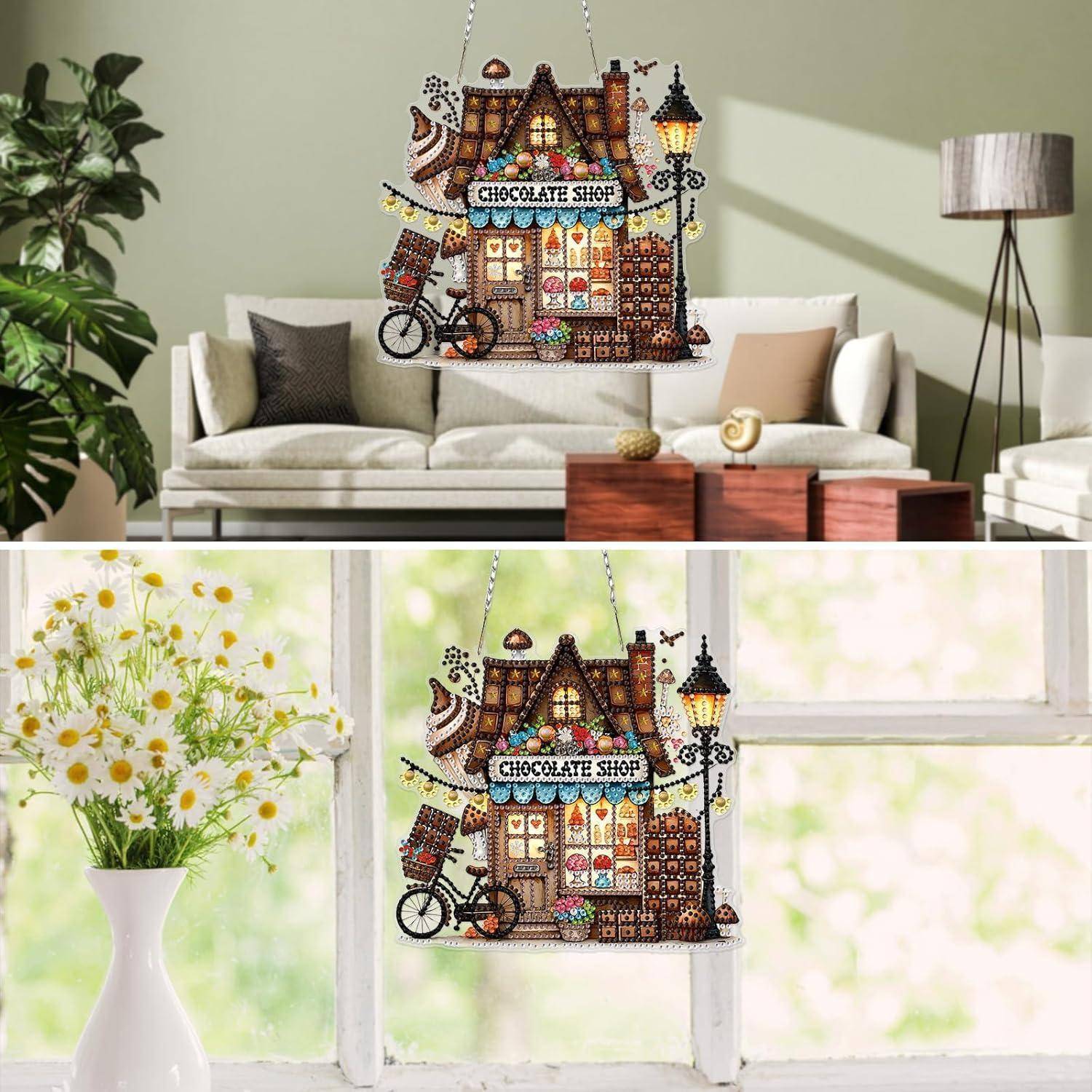 Dekoratives Schokoladenladen-Hängeornament, das in einem Wohnzimmer und am Fenster angebracht ist, dargestellt als fantasievolle Miniatur-Ladenfront mit Fahrrad und Lampe.