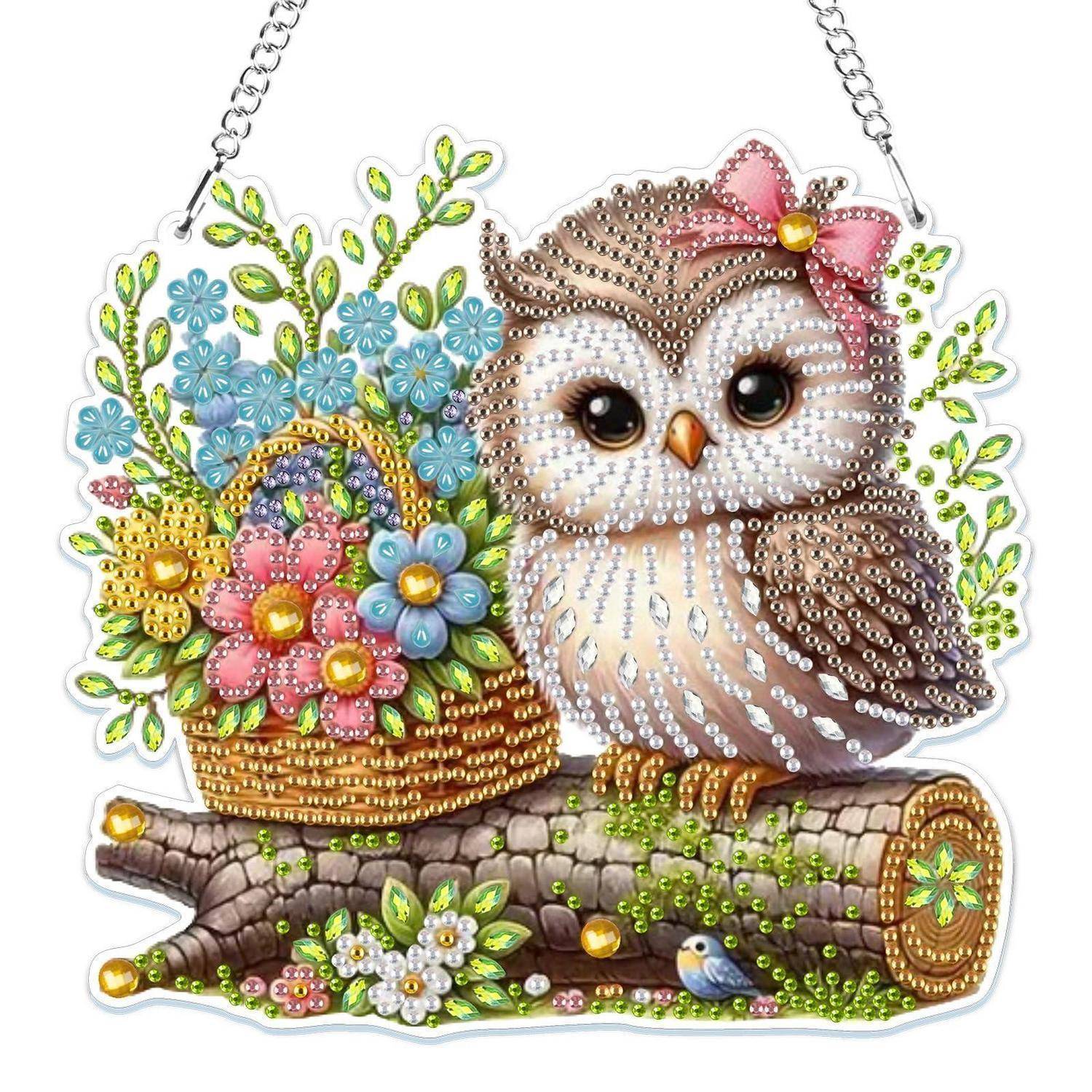 Dekorative Eulenfigur auf einem Ast neben einem Blumenkorb, mit farbenfrohen perlenähnlichen Details bedeckt und an einer Kette hängend.