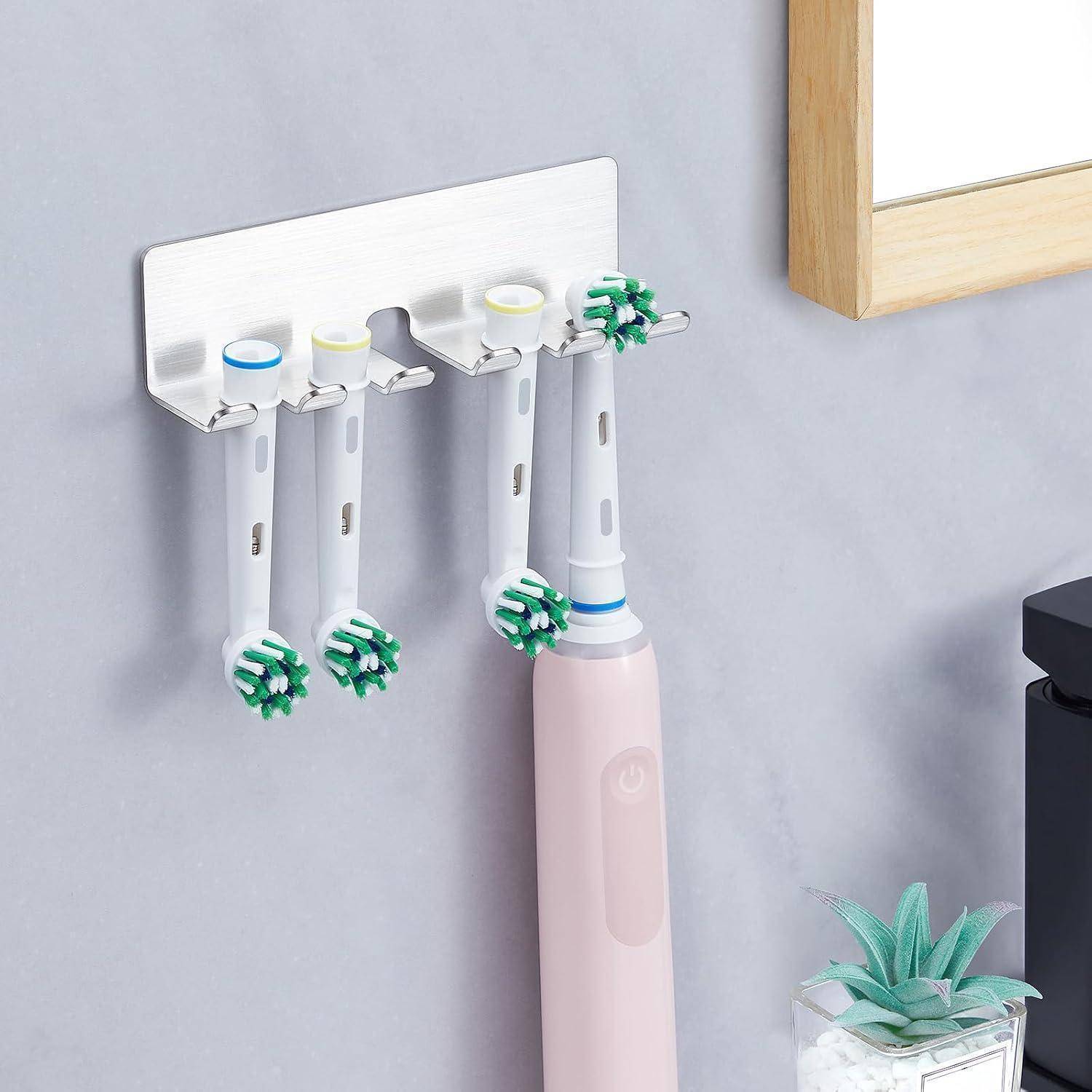 Wandmontierte Halterung speichert elektrische Zahnbürsten und Zahnpasta im Badezimmer, mit vier Zahnbürsten, die kopfüber zum Trocknen hängen.