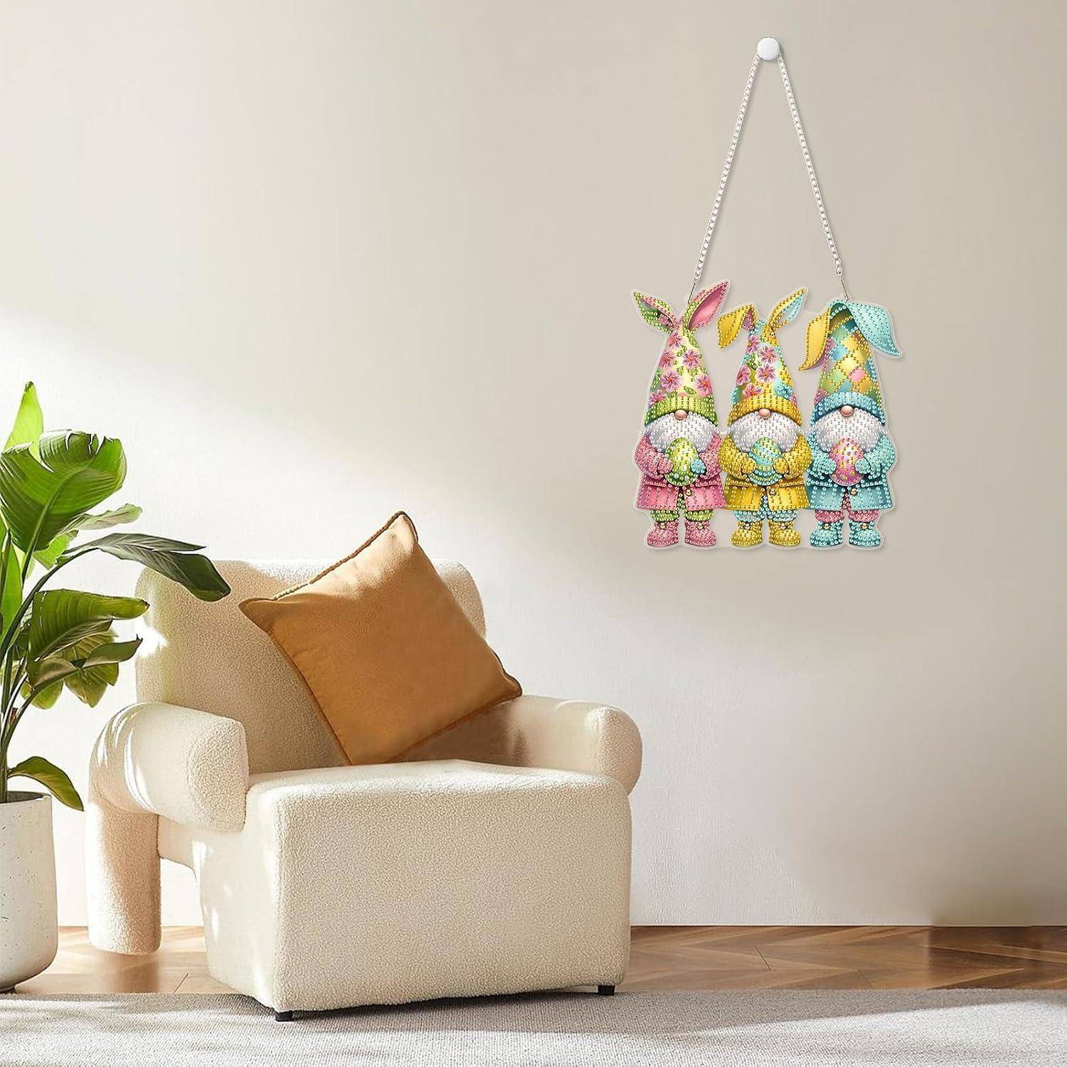 Cremefarbener Sessel mit beigem Kissen neben einer Topfpflanze, unter einer Wanddekoration mit drei bunten Hasenfiguren an einer schlichten Wand.