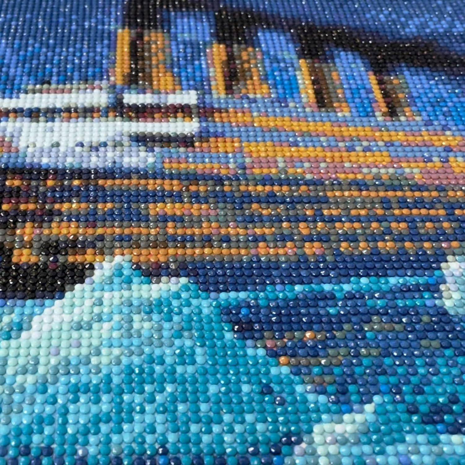 Nahaufnahme eines bunten Perlenmosaiks, das eine Stadtsilhouette über Wasser darstellt, mit blauen Wellen im Vordergrund.