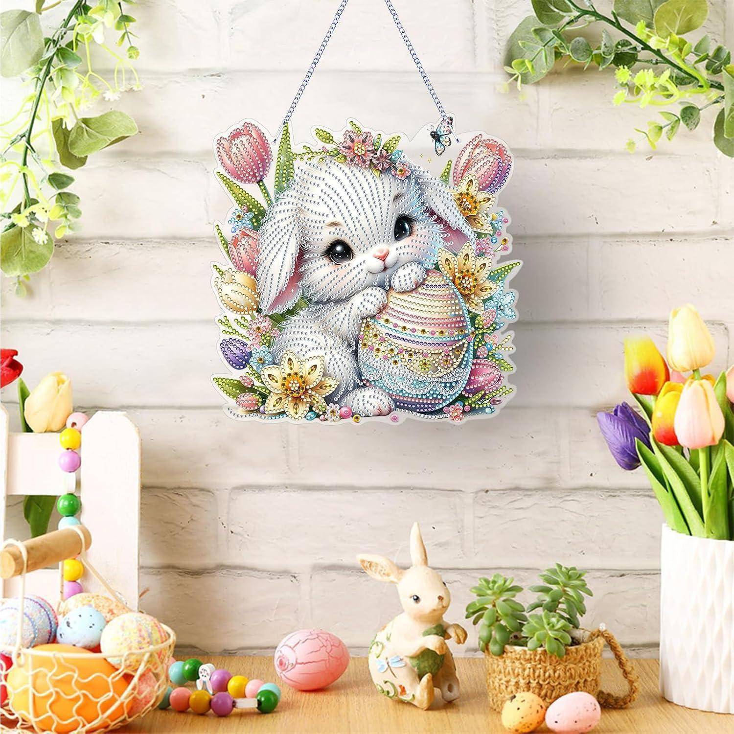 Osterhasen-Wandbehang mit Pastelleiern und Blumen, an einer weißen Backsteinwand über einem festlichen Frühjahrstisch mit Kerzen, Eiern, einer Hasenfigur und Tulpen ausgestellt.