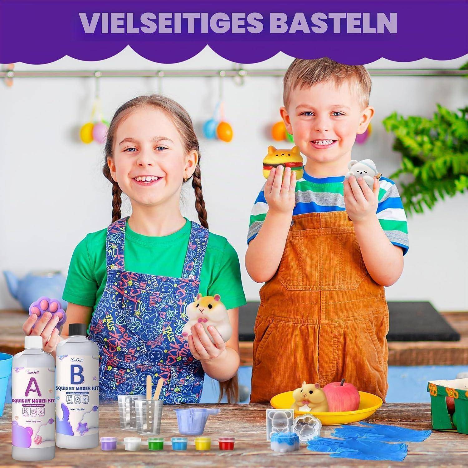 Zwei lächelnde Kinder präsentieren bunte selbstgemachte Tonarbeiten an einem Tisch mit Farben und Werkzeugen unter dem Titel „VIELSEITIGES BASTELN