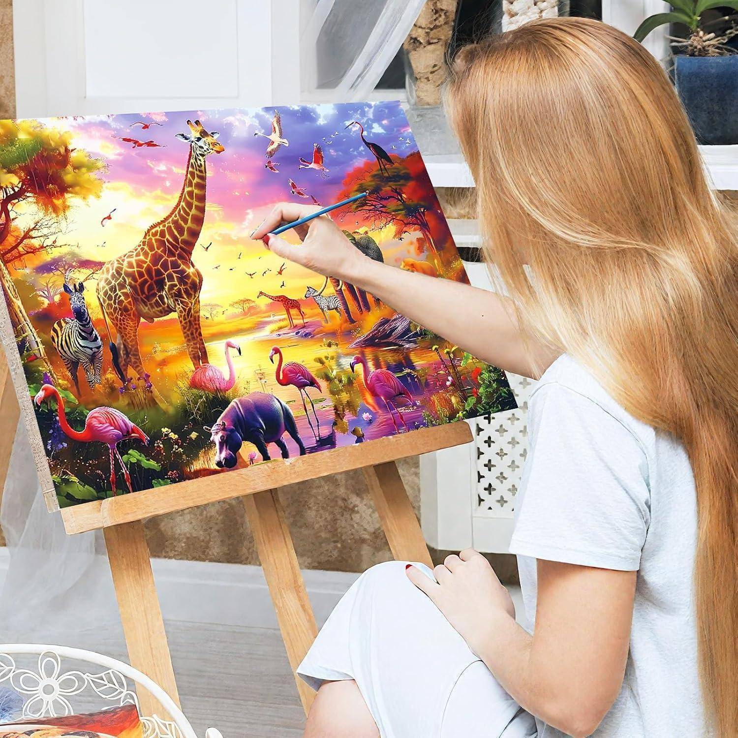 Eine Frau malt eine lebendige Wildnisszene auf einer Staffelei, mit Giraffe, Zebra, Vögeln und Sonnenuntergangsfarben.