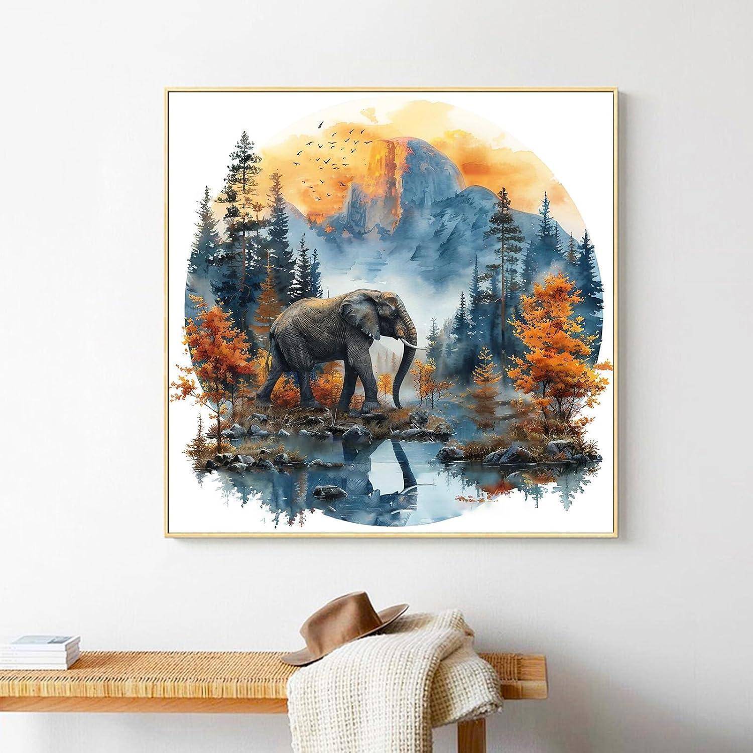 Wandkunst in einem Rahmen, die einen Elefanten an einem Bergsee bei Sonnenaufgang zeigt, mit Herbstbäumen und Spiegelungen, hängend über einer Bank mit einem Hut und einer Decke.