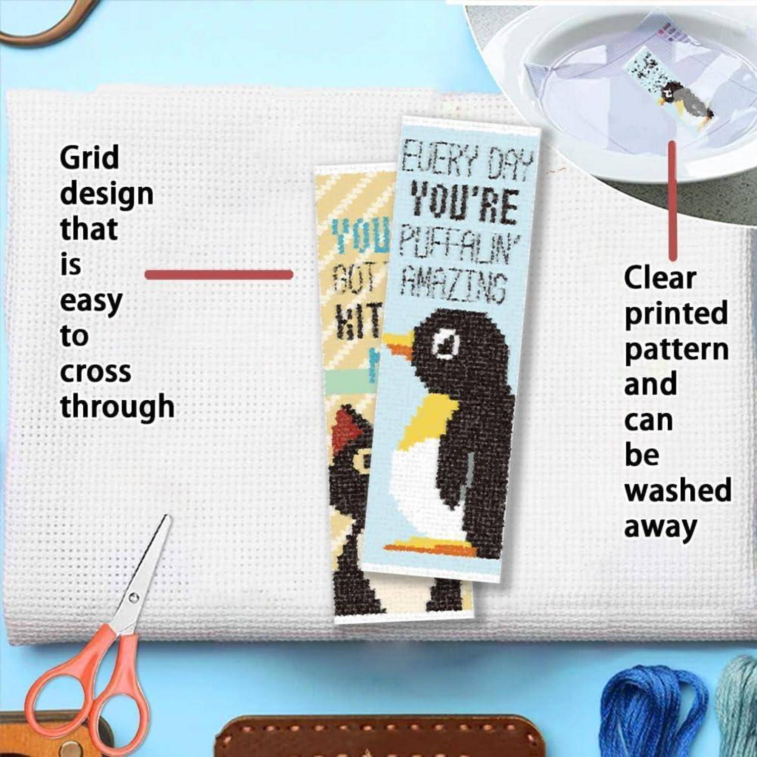 Stickerei-Stoff mit aufgedrucktem Gitter, das auswaschbar ist, gezeigt mit Beispiel-Pinguin-Designs und Schere.