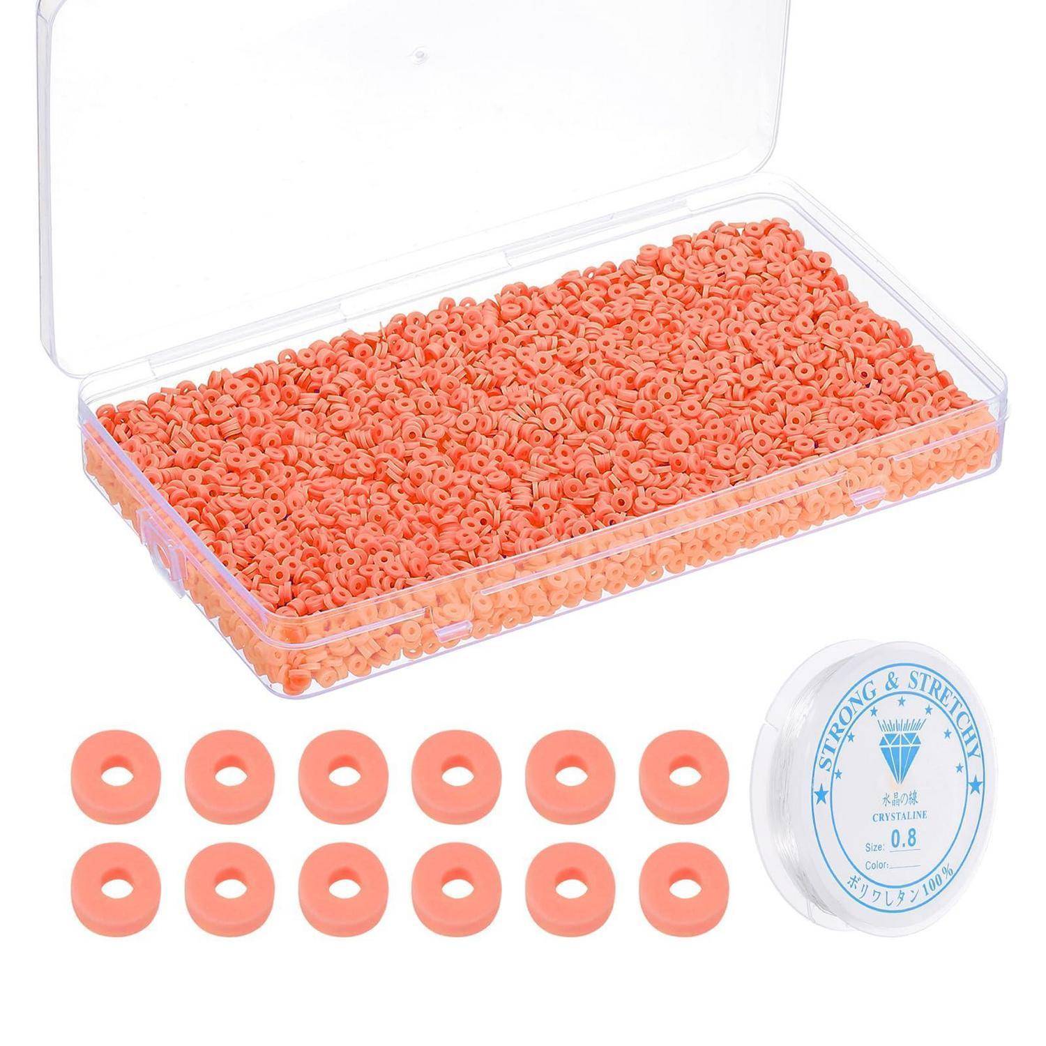 Durchsichtige Kunststoffbox gefüllt mit orangefarbenen donutförmigen Perlen, mit einigen darunter angeordneten Perlen und einer Spule mit der Aufschrift „Strong & Stretchy