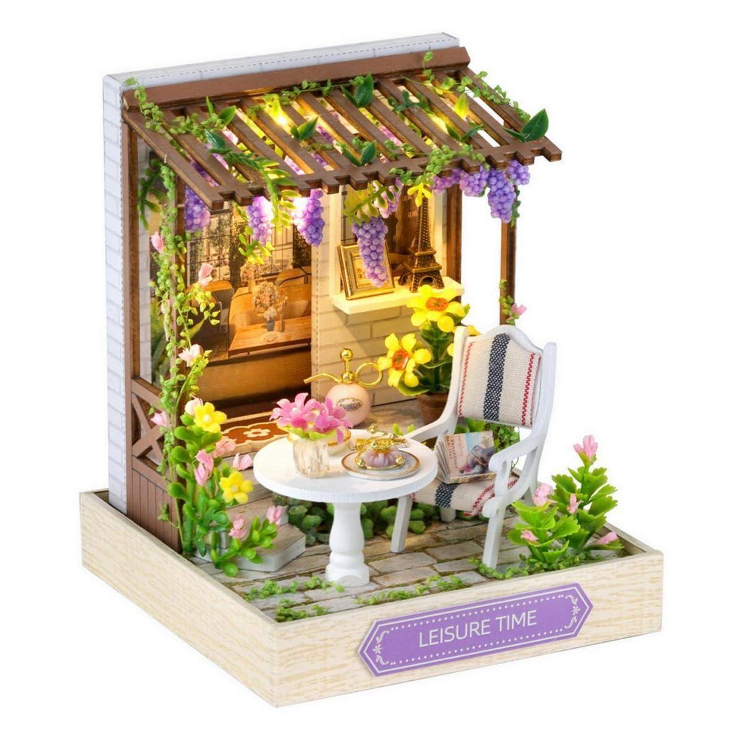 Miniaturhafte Gartenpatio-Ausstellung mit Stuhl, Tisch, Blumen, Weinranken-Spalier und dem Label „LEISURE TIME