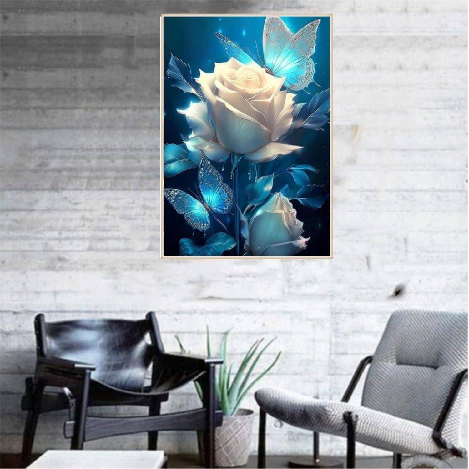 Gerahmte Wandkunst mit weißen Rosen und leuchtenden blauen Schmetterlingen über einem Sitzbereich mit schwarzen und grauen Stühlen und einer Topfpflanze.