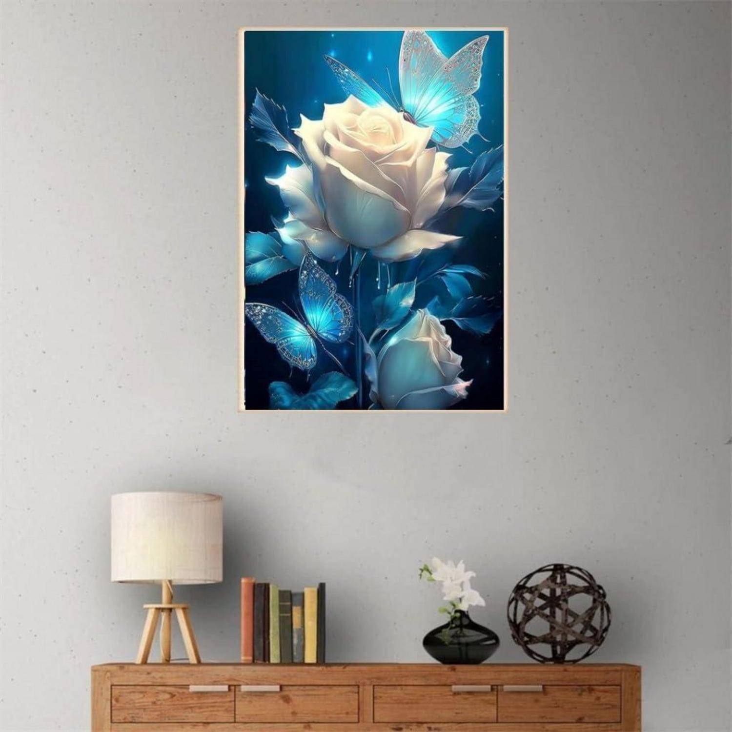 Gerahmte Wandkunst mit leuchtend weißen Rosen und blauen Schmetterlingen über einem Holz-Sideboard in einem minimalistischen Zimmer.