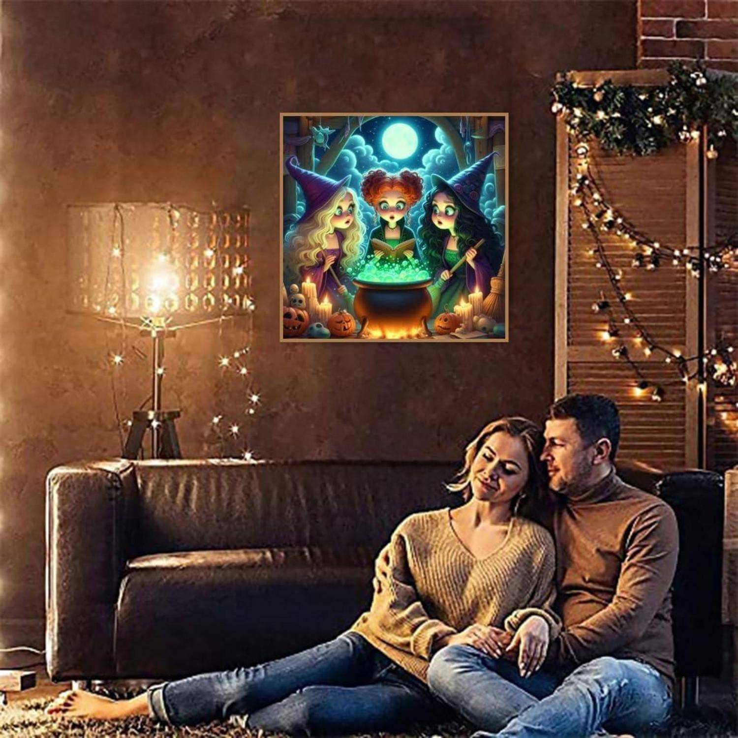 Ein Paar entspannt sich auf einem Sofa in einem warm beleuchteten Wohnzimmer, mit einer leuchtenden Lampe, Lichterketten und einer gerahmten Halloween-Hexen-Illustration an der Wand.
