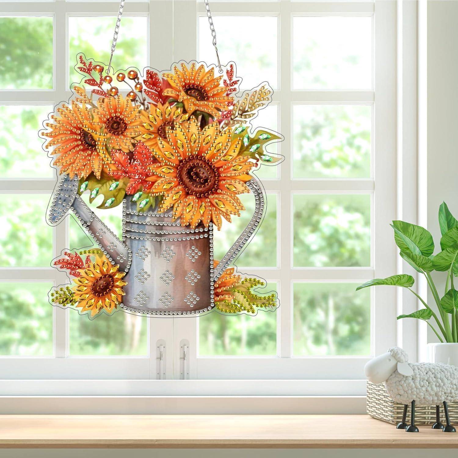 Dekorative hängende Metallgießkanne gefüllt mit leuchtenden Sonnenblumenblüten, vor einem Fenster aufgestellt.