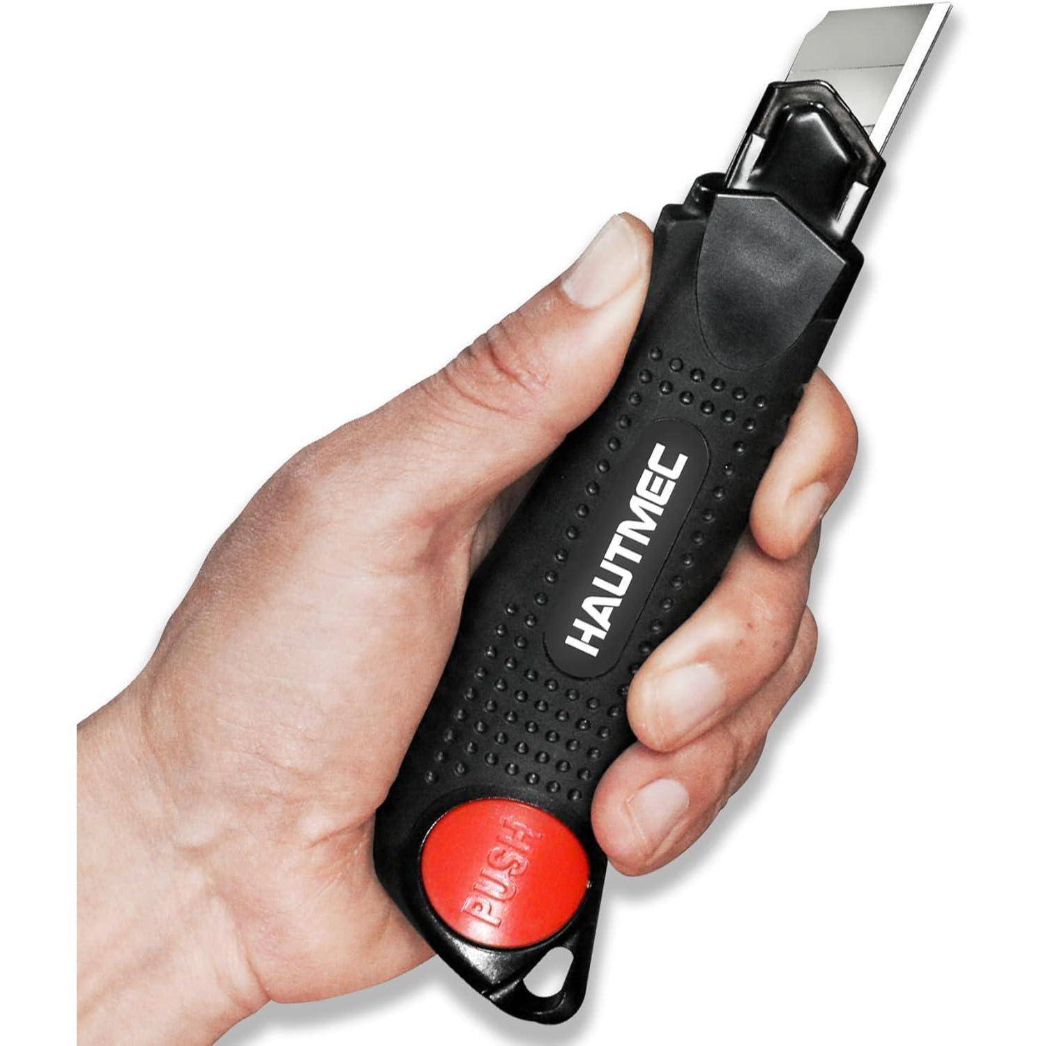 Hand, die ein schwarzes HAUTMEC-Universalmesser mit ausgefahrener Klinge und einer sichtbaren roten Freigabetaste am Daumen hält.