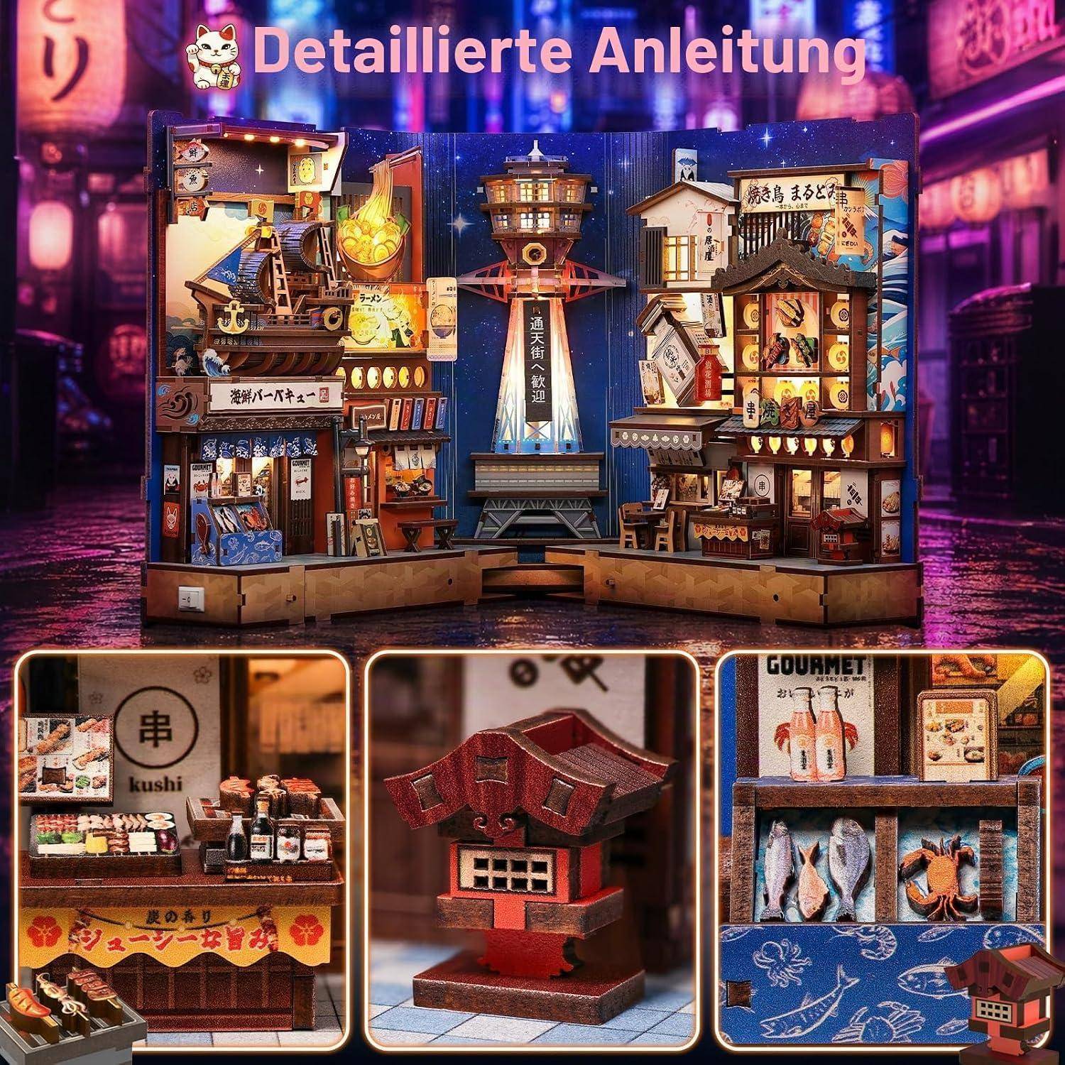 Detaillierte Miniatur-Anzeige eines japanischen Straßenlebensmittelmarktes mit mehreren beleuchteten Ständen und einem zentralen Turm; drei Nahaufnahmen zeigen einen Sushi-/Kushi-Stand, ein rotes schreinähnliches Modell und einen Gourmet-Meeresfrüchte-Stand.