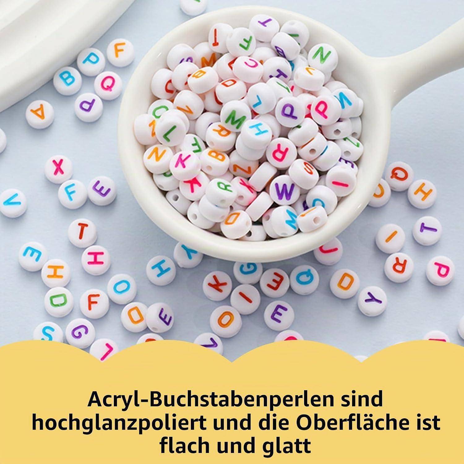 Schale mit bunten Buchstabenwürfelchen mit verstreuten Perlen rundherum, die Acryl-Buchstabenwürfelchen illustriert; der deutsche Text besagt, dass sie hochglanzpoliert sind mit einer flachen, glatten Oberfläche.
