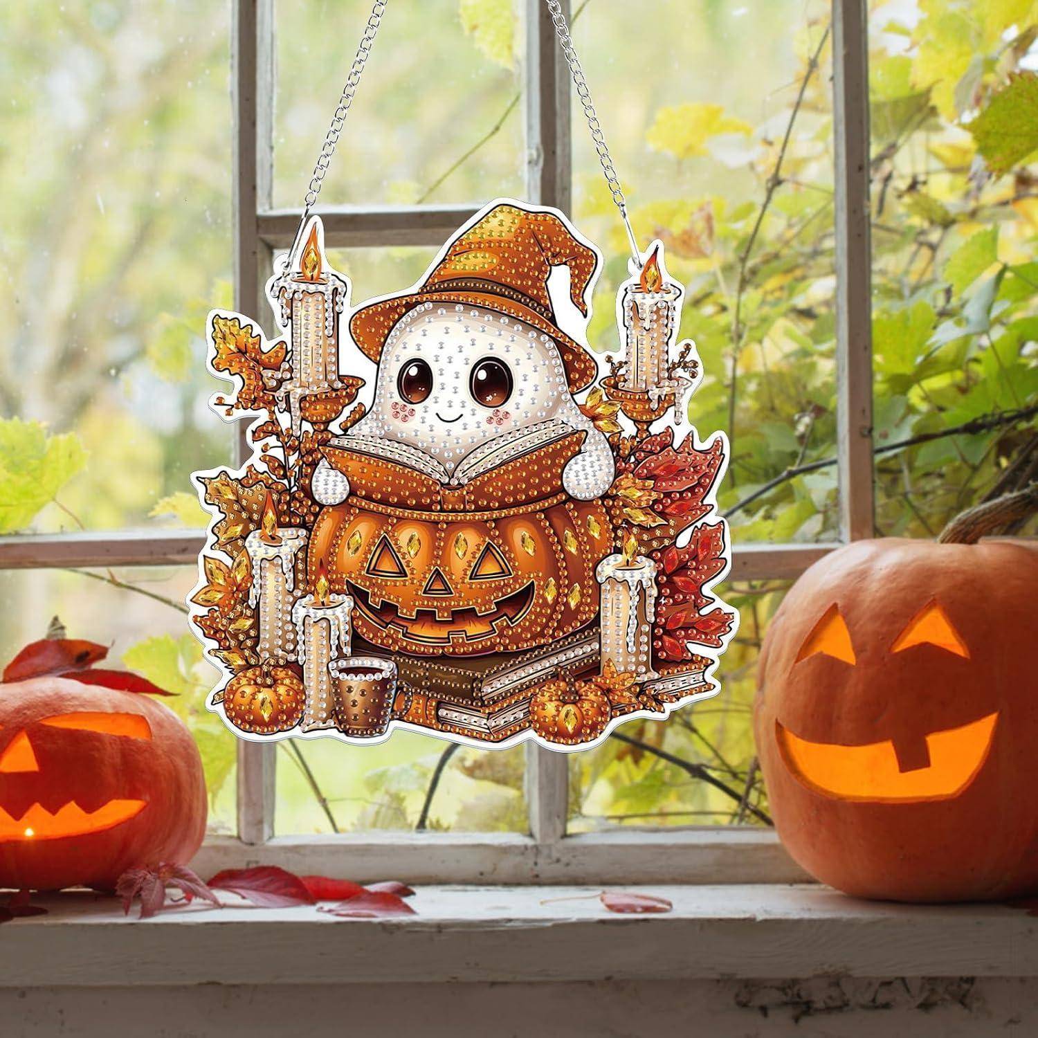Halloween-Fensterdekoration mit einem niedlichen Gespenst in einem Hexenhut, das in einem Kürbisgesicht sitzt, flankiert von Kerzen, mit echten geschnitzten Kürbissen auf beiden Seiten.