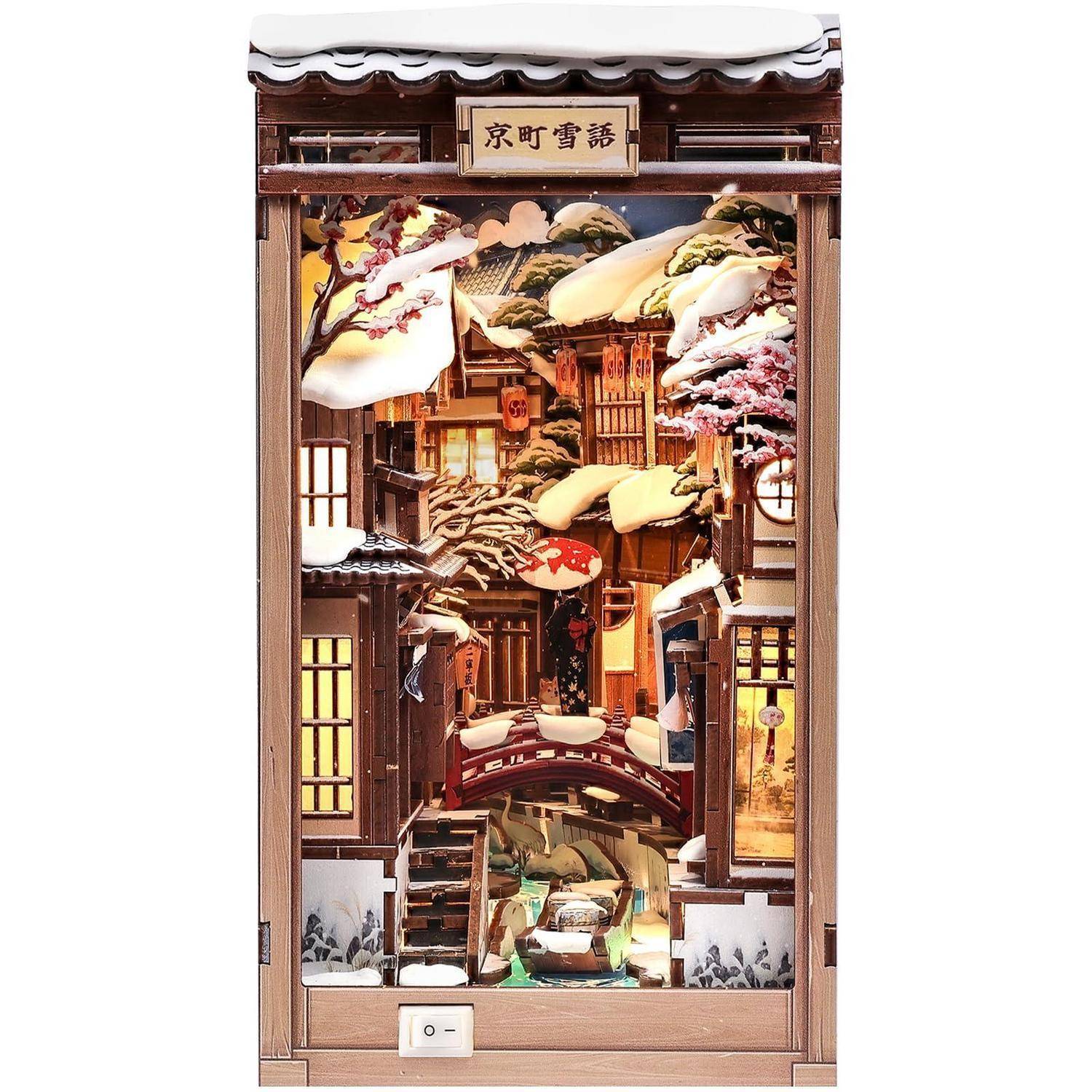 Miniatur-Holzdiorama einer traditionellen japanischen Winterstraßenszene mit schneebedeckten Dächern, Laternen und Ladenfront in einer Vitrine.