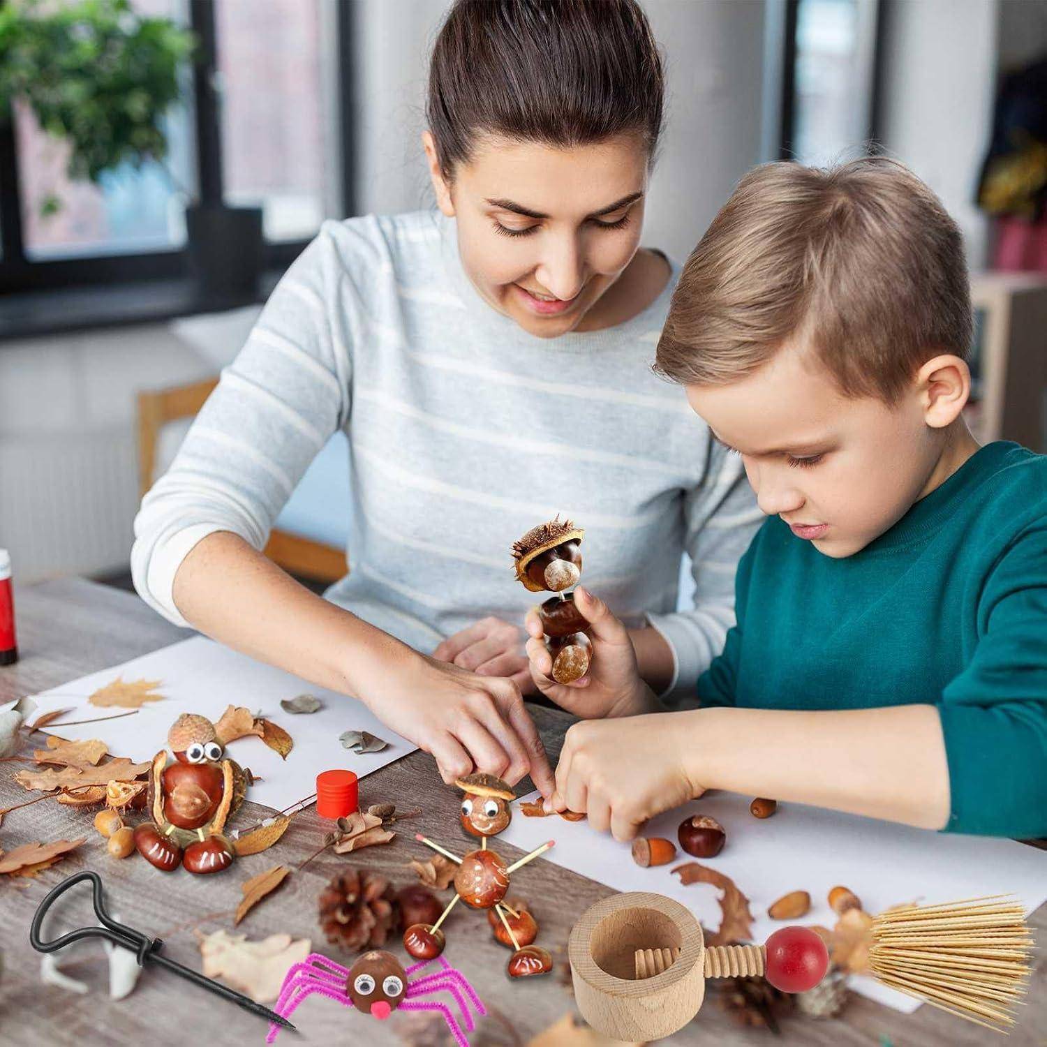 Frau und kleiner Junge basteln an einem Tisch mit Eicheln, Blättern und Ästen und erstellen kleine Herbstfiguren und Dekorationen.