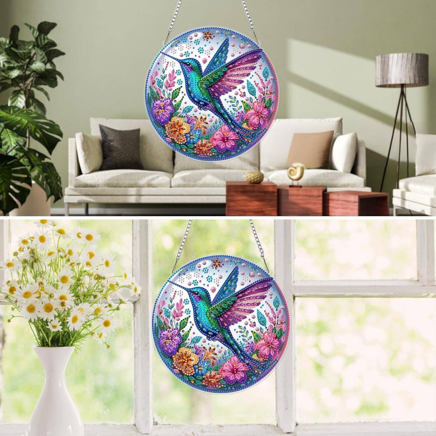 Kunstwerk aus rundem Kolibri-Mosaik zum Aufhängen mit bunten Blumen, gezeigt als dekorative Wand- oder Fensterausstellung in einem hellen Wohnzimmer.
