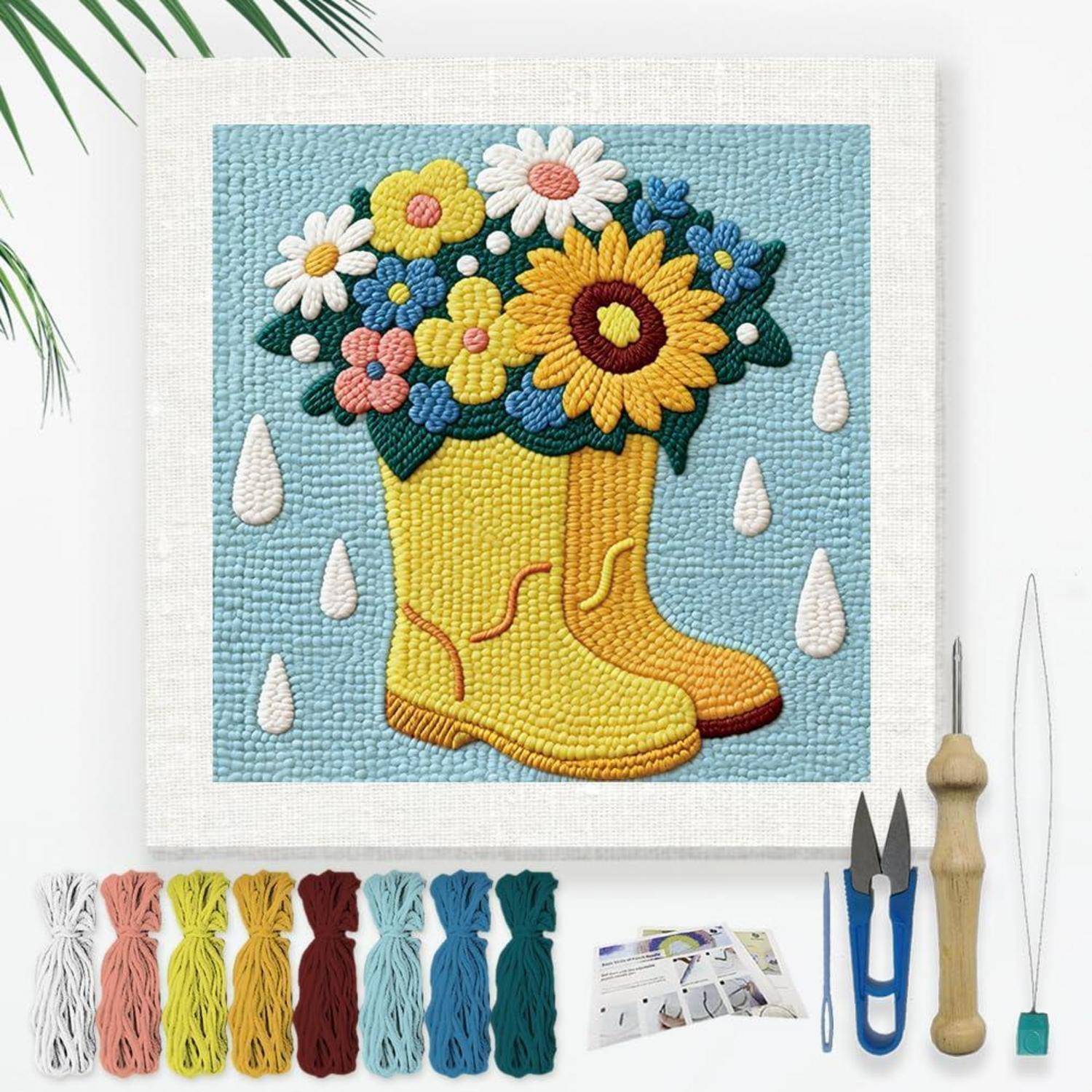 Fertiggestellte getuftet Wandkunst von gelben Regenstiefeln gefüllt mit Blumen, gezeigt mit Teppichherstellungs-Utensilien und Werkzeugen rundherum.
