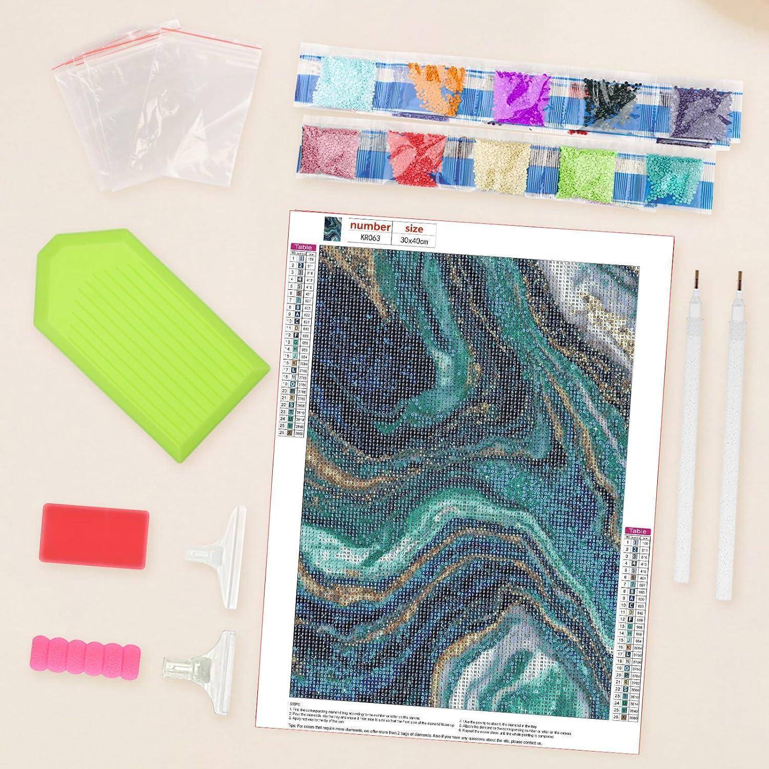 Diamond-Painting-Set mit marmoriertem Blaugrün- und Graumuster-Diagramm, Farbbohrer-Päckchen, grünem Tablett, Applikator-Stiften und Wachshaltern.