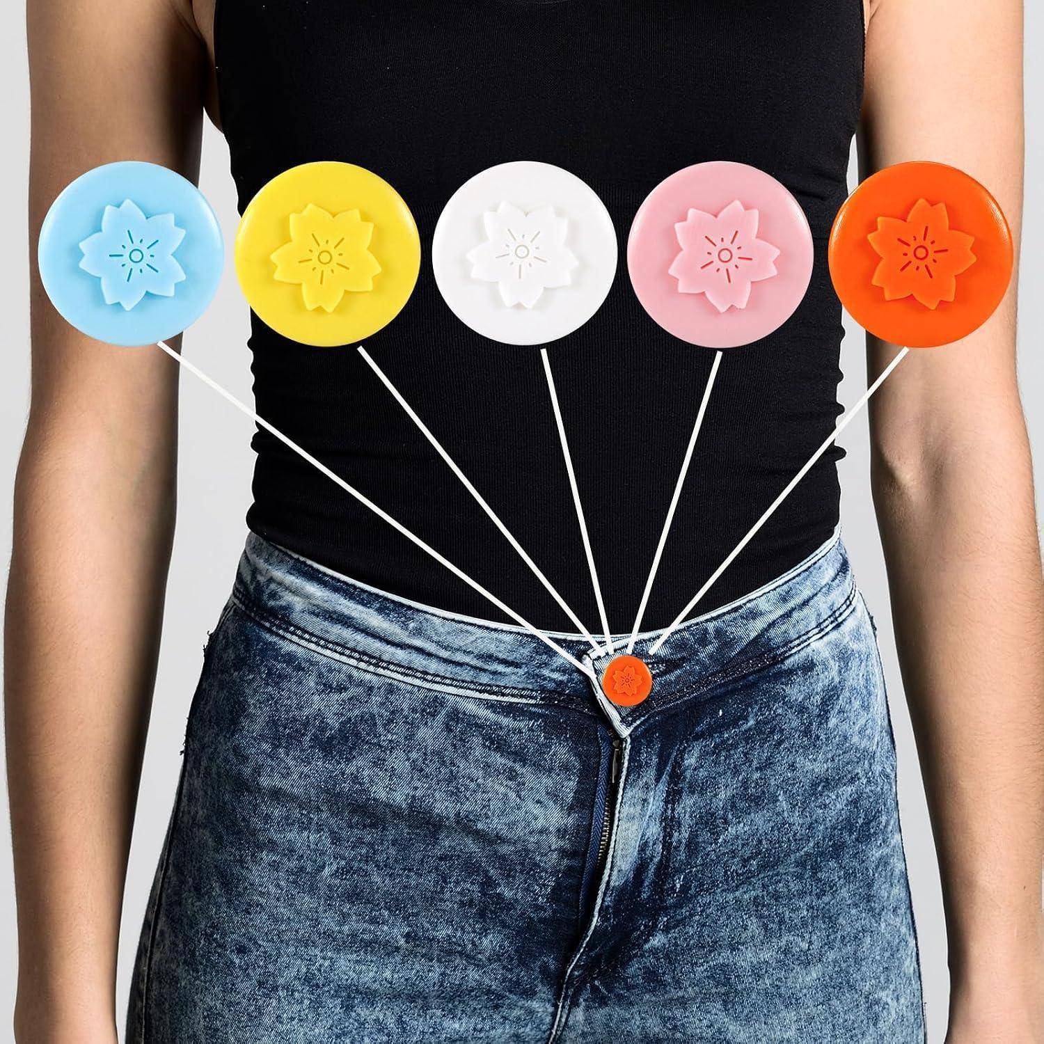 Diagramm des Oberkörpers einer Frau mit fünf farbigen runden Stecknadeln, die durch Schnüre mit einer zentralen orangefarbenen Taille-Stecknadel verbunden sind und Körperbereiche veranschaulichen, die mit einem Punkt verbunden sind.