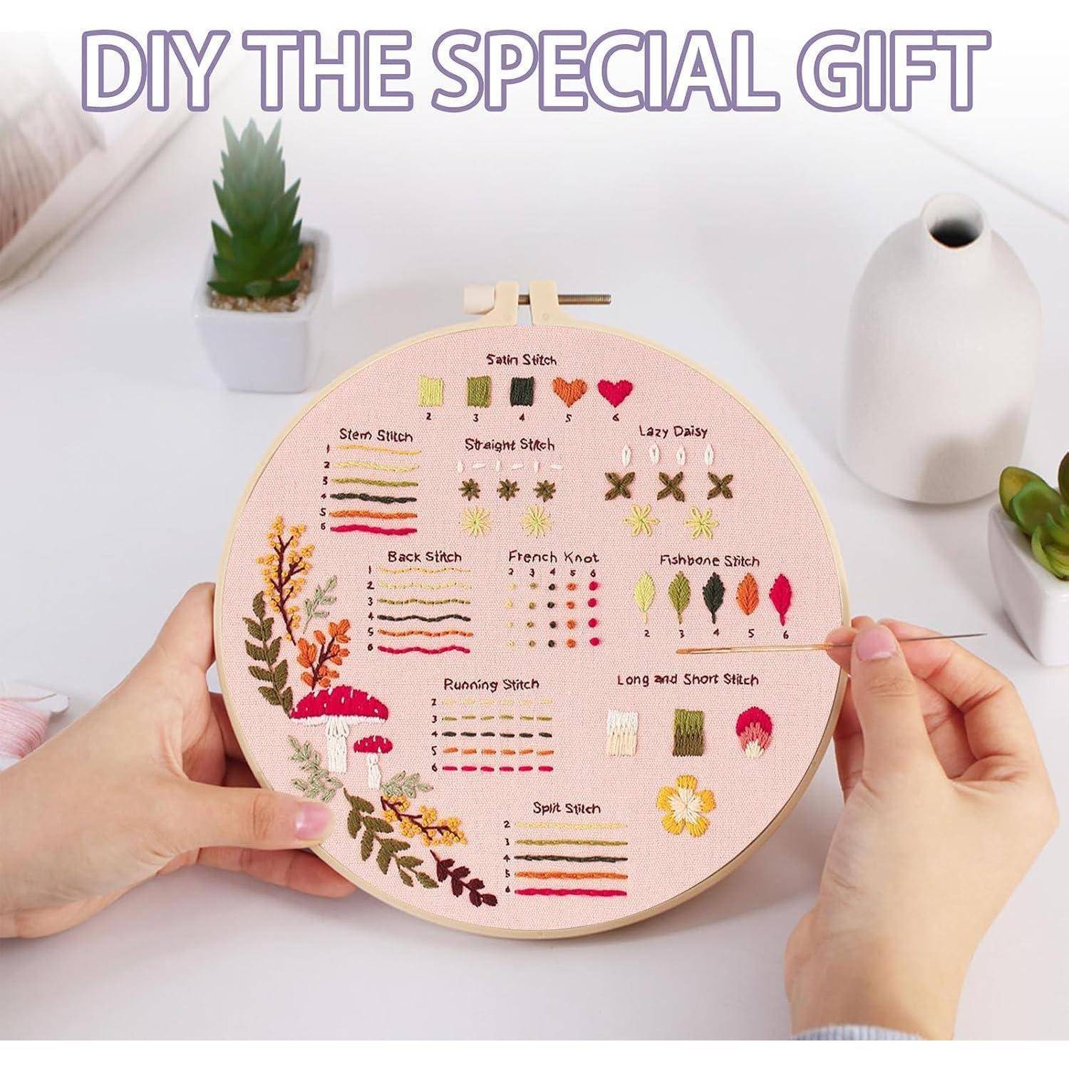 Hände halten einen Stickrahmen mit einer gestickten Stickanleitungs-Mustersammlung mit beschrifteten Fadenmuster und Blumendesign; der Text lautet „DIY DAS SPEZIELLE GESCHENK".