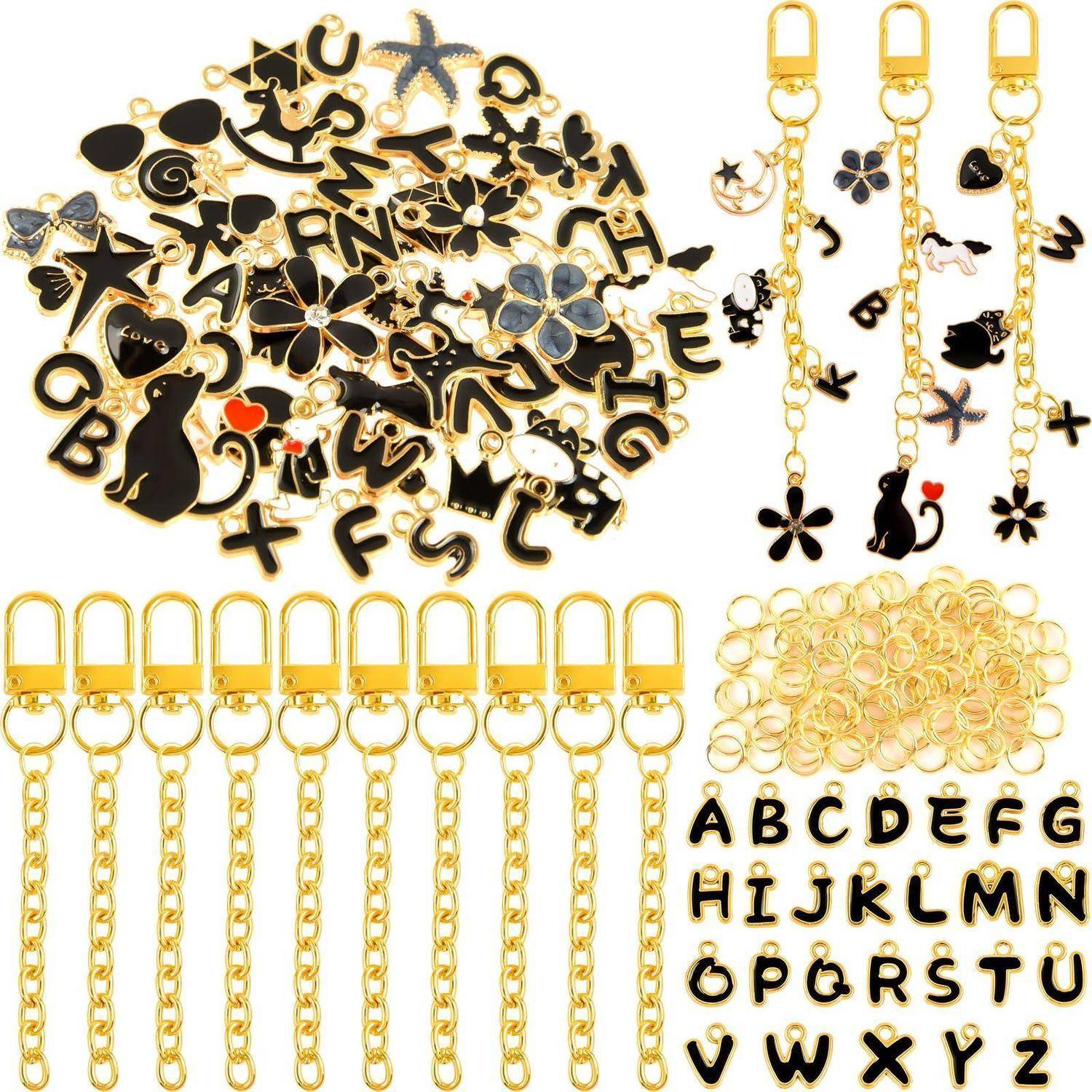 Assortierte Gold-und-Schwarz-Buchstaben-, Herz-, Stern- und Katzen-Anhänger, plus Ketten und Schlüsselanhänger mit Alphabetbuchstaben und Ringen für die Schmuckherstellung.