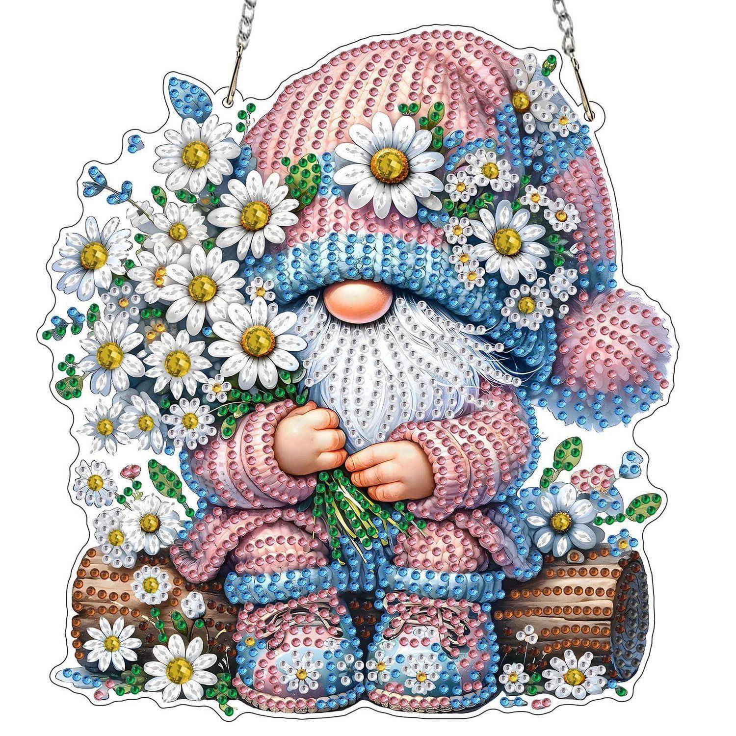 Beadte Gnomdekoration mit rosa Hut und Kleidung, weißem Bart, haltend Blumen neben Gänseblümchen und einem Holzscheit.