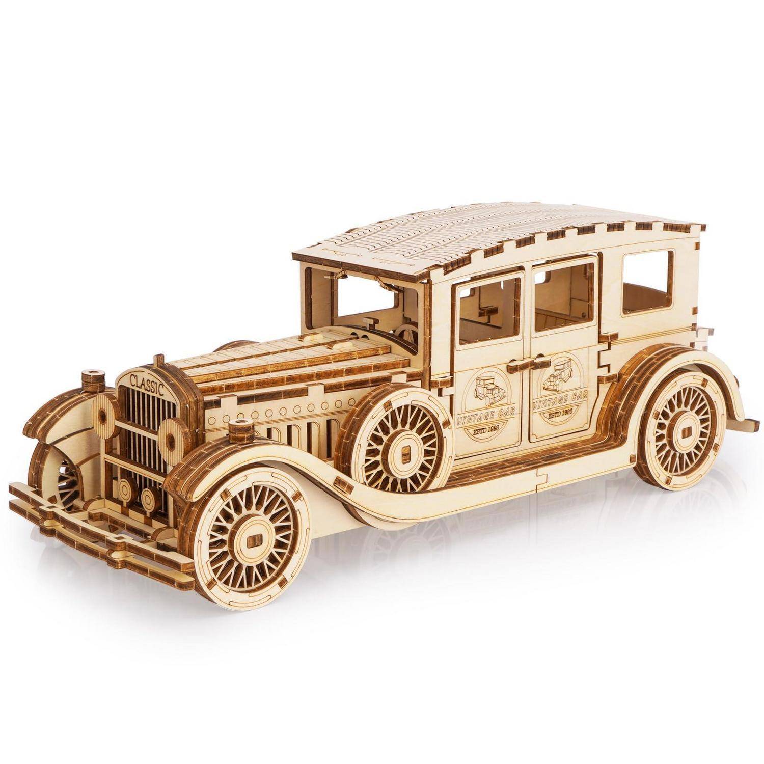 Ein hölzernes Modell eines klassischen Vintage-Autos mit detaillierten Rädern, Kühlergrill und kantigem Karosserie, auf einem einfachen weißen Hintergrund dargestellt.
