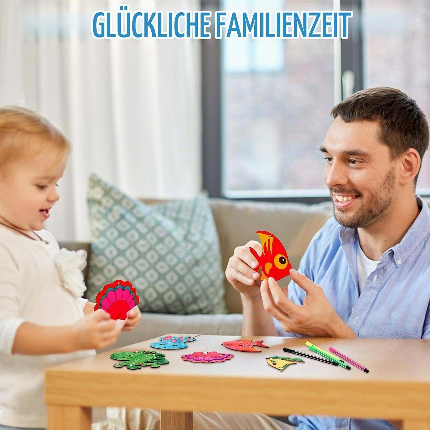 Vater und kleines Kind spielen an einem Tisch mit bunten Papierbastelelementen; der Text lautet „GLÜCKLICHE FAMILIENZEIT".