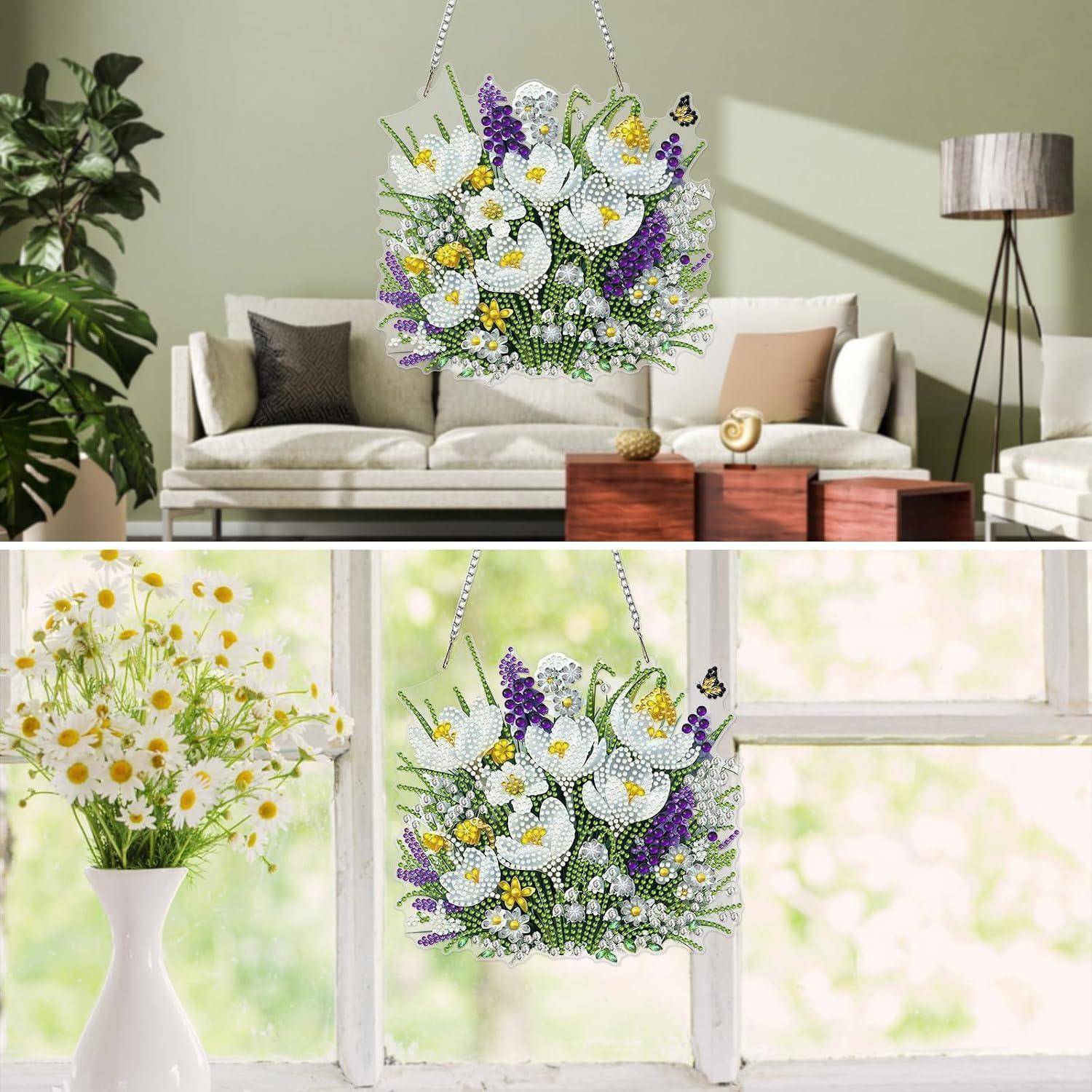 Rundes hängendes Blumenarrangement aus weißen, gelben und violetten Blumen, das drinnen in einem Wohnzimmer neben einem hellen Fenster präsentiert wird.