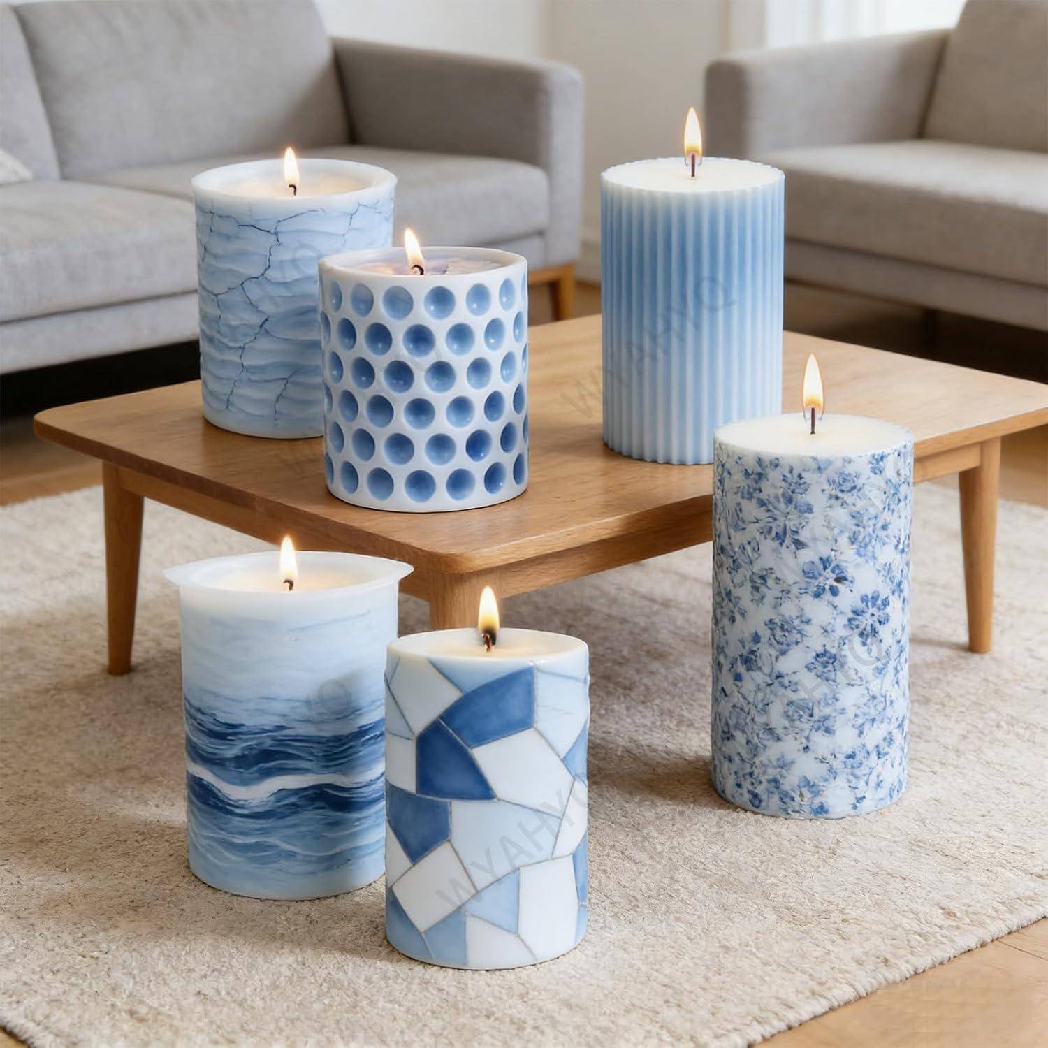 Fünf brennende dekorative Säulenkerzen mit blau-weißen Mustern auf einem hölzernen Couchtisch in einem Wohnzimmer angeordnet.
